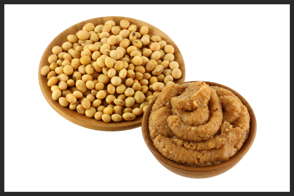 A Bowl of Thick Miso Paste next to Dried Soybeans