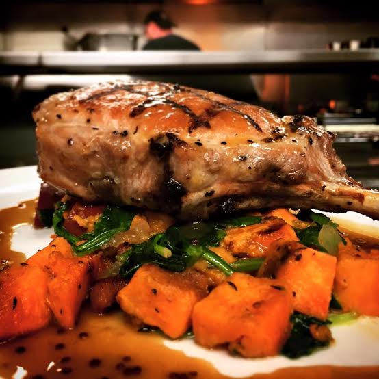 Grilled Duroc Pork Chop with sweet potato andouille hash, baby spinach & bourbon mustard glace at Victoria Gastro Pub | Credit: Facebook