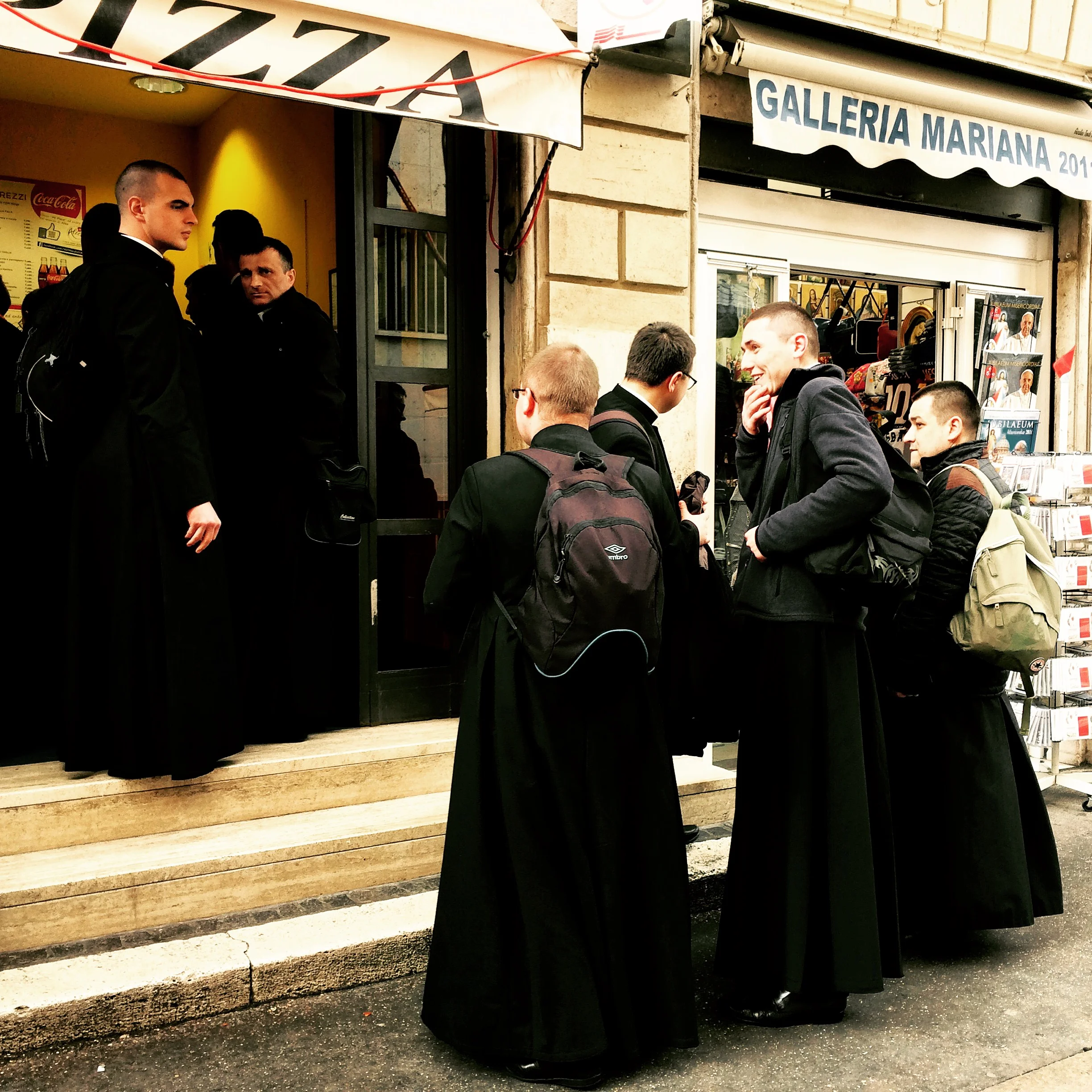 Priests stop for pizza near Vatican in Rome, Italy