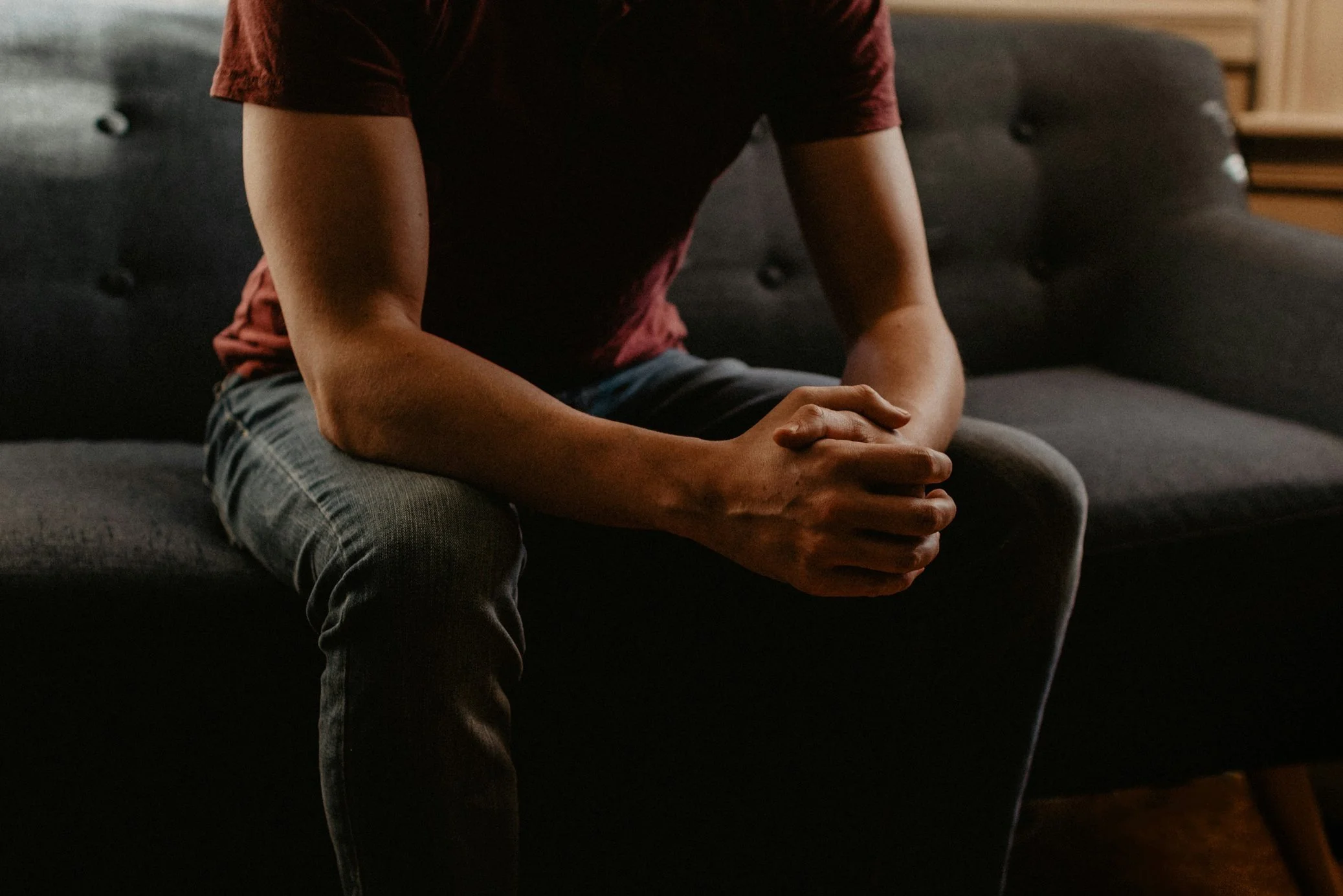 Individual holding his hands while asking questions about sex therapy