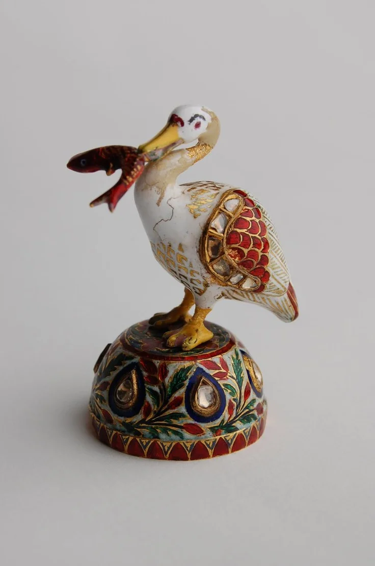 Gold and enamel figurine of bird on a stand, set with diamonds, with a fish in its beak. Mughal. British Museum
