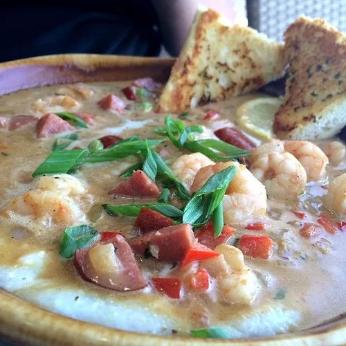 Shrimp ‘n Grits ( @BrokenEggCafe) Shrimp & Andouille sausage sauté, spicy low country reduction sauce, sautéed red bell peppers & onions on creamy cheese grits with garlic French bread