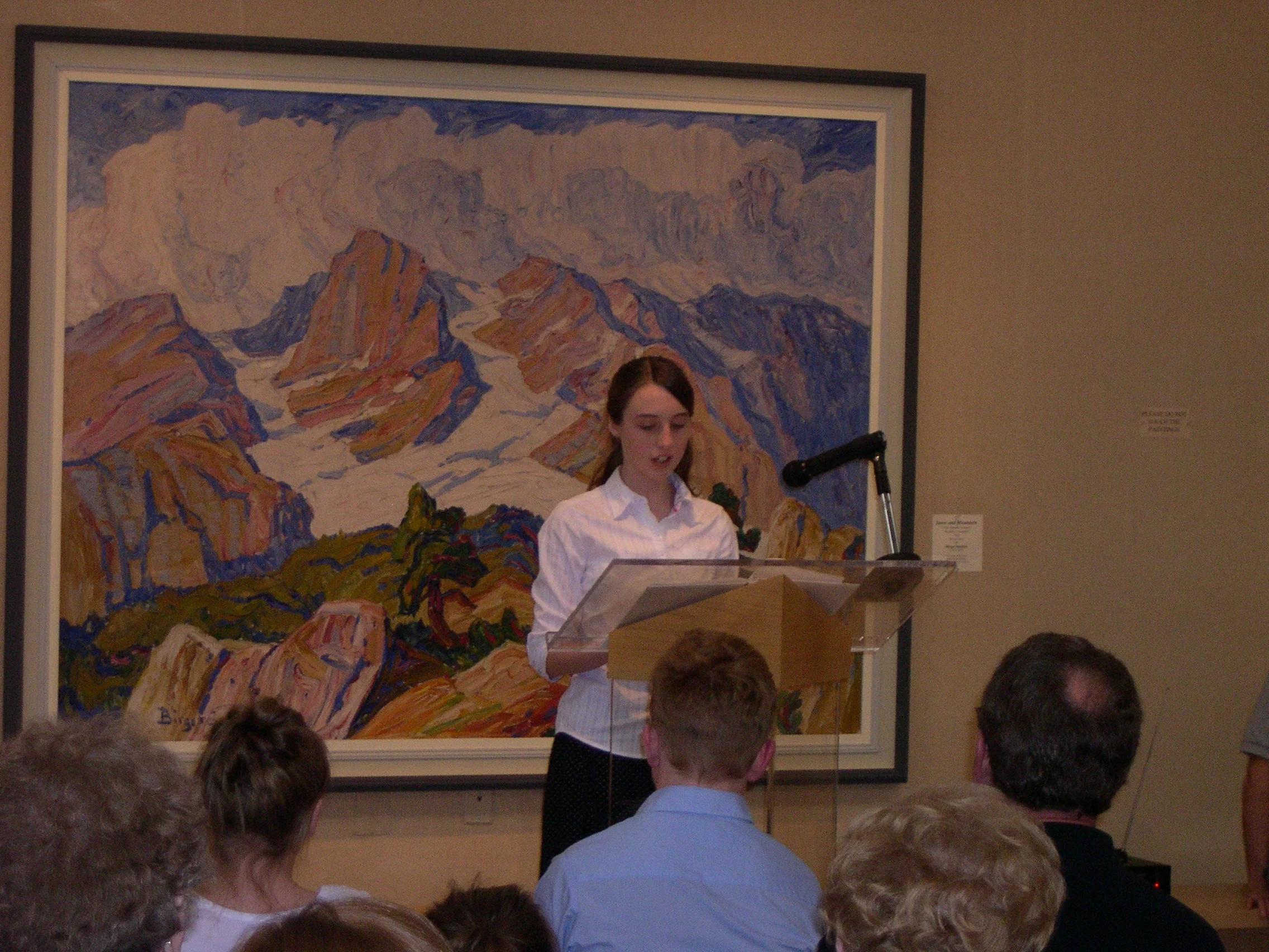 Lindsborg Middle School students presenting their personal writing at the Sandzen Art Gallery. A Sandzen oil painting provides a lovely backdrop.