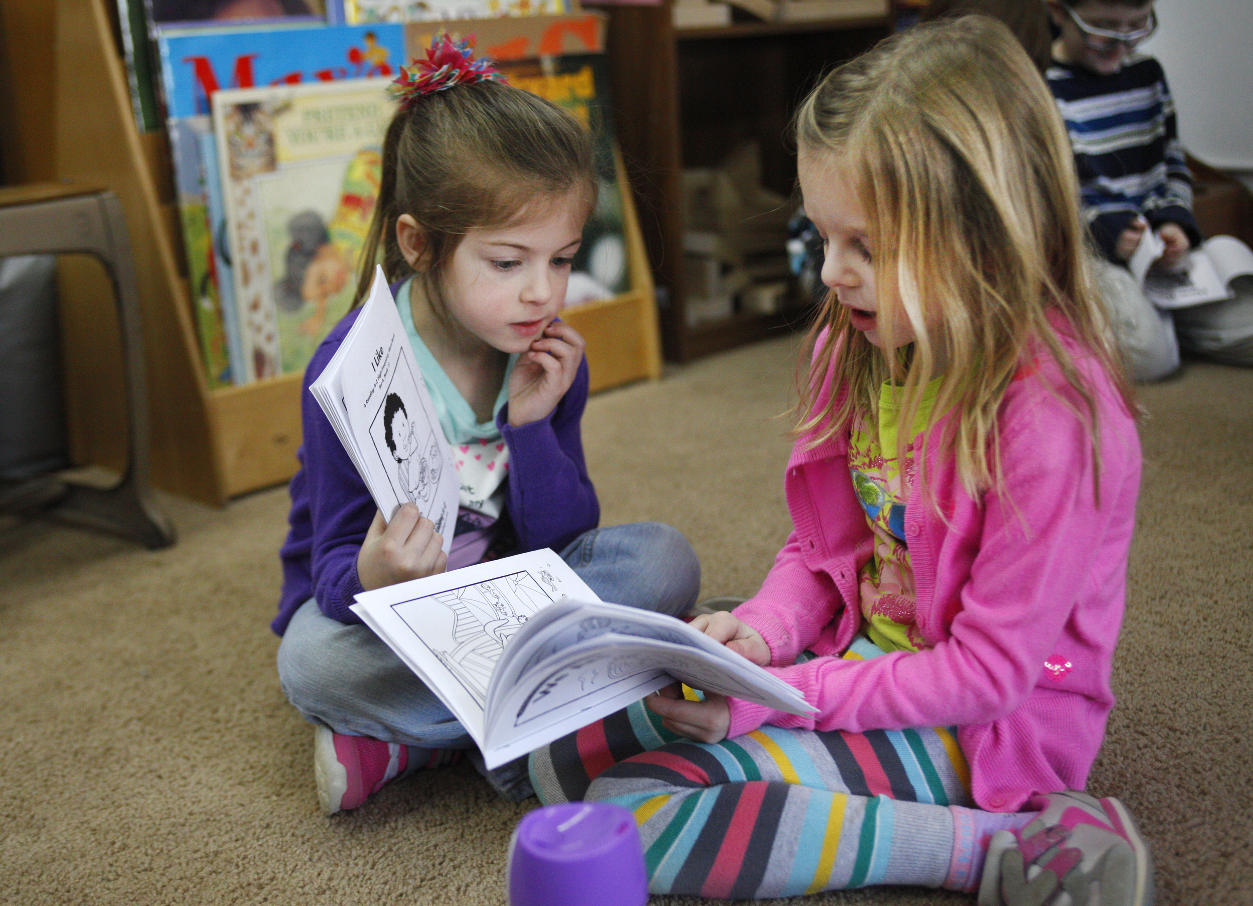 Ava Djordjevich, right, reads a book to Finley Johnson Monday at Seton Catholic School. Students in Mrs. Carson’s kindergarden class read to each other daily. 