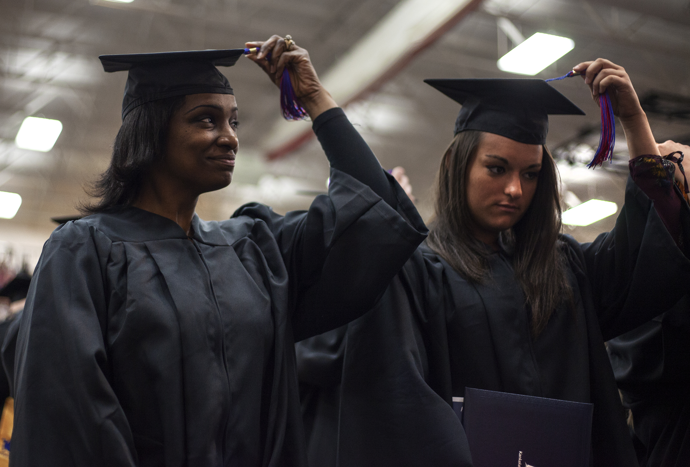  Chauncia Akins, left, and Jenna Arseneau, turn their cap tassels Saturday to signify the closing of the graduation ceremony at Kankakee Community College. 