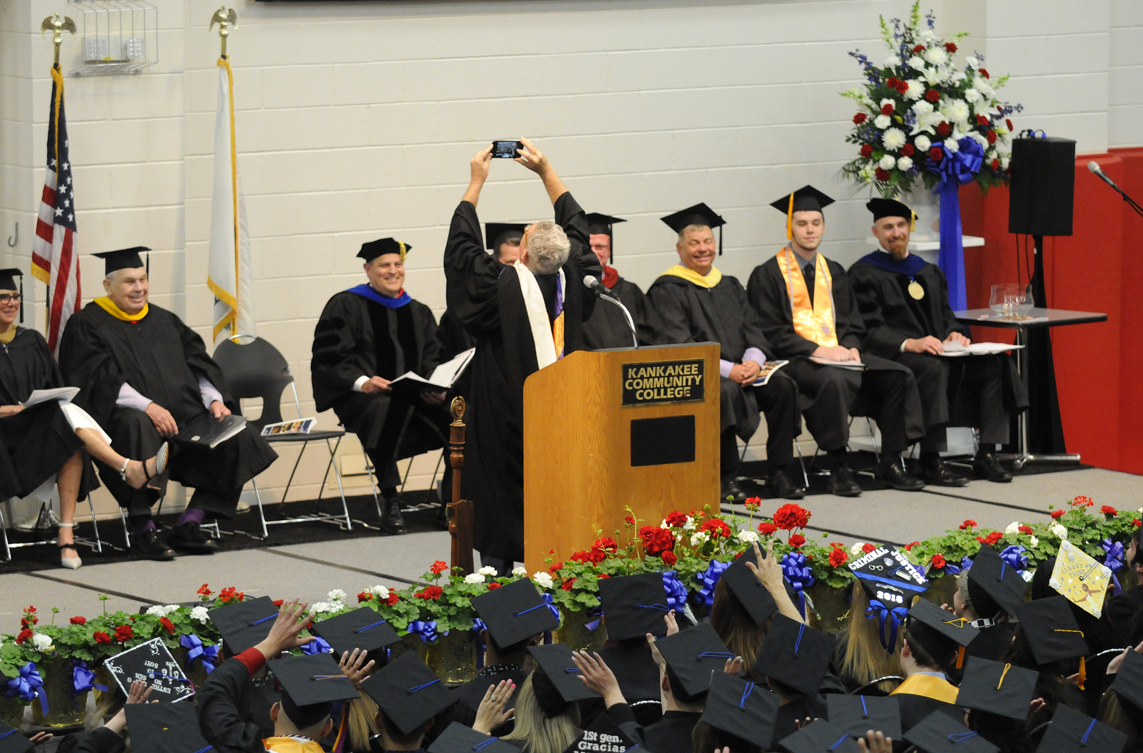  Commencement speaker Ed Emerson takes a selfie with the crowd Saturday during the Kankakee Community College graduation. Emerson, a political strategist, told the students “The key to success is to say yes.”    