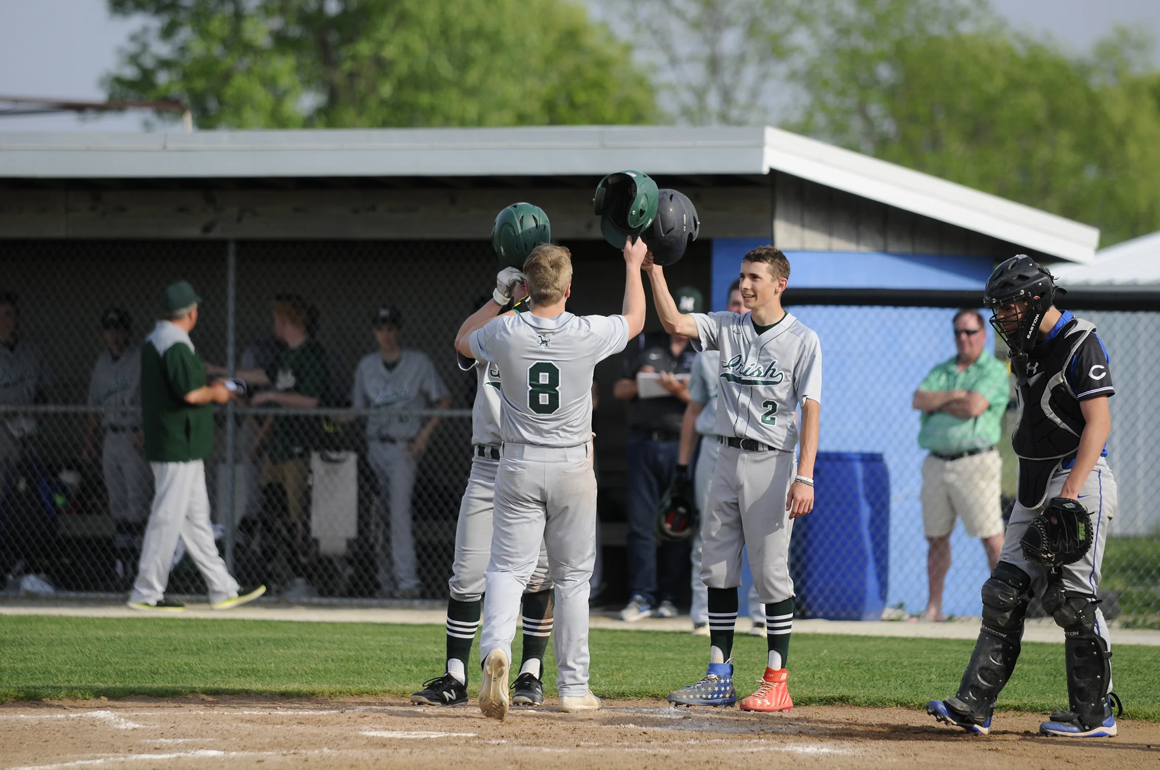 Teammates congratulate Bishop McNamara’s Tyler Hiller after a home run hit Monday during the game against Clifton Central. Bishop McNamara’s Fightin’ Irish won the game 14-0 to end the season for the Clifton Central Comets.