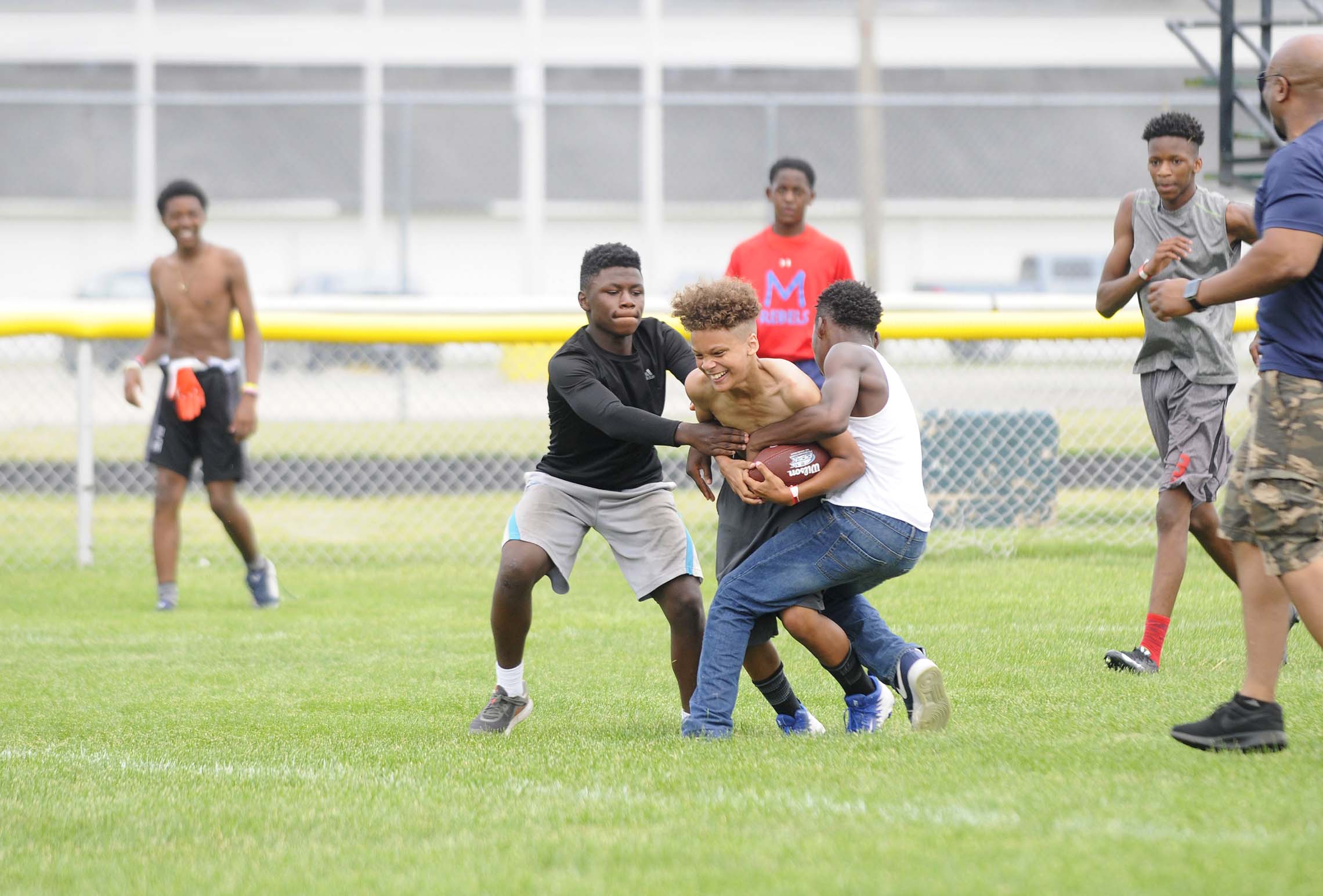  A participant in Haglers 12th Annual Kidz-Kan-Do Football and Cheerleading Camp is tackled Saturday on the football field at Bishop McNamara High School in Kankakee. The camp is hosted by the Tyjuan Hagler Foundation and includes various football dr