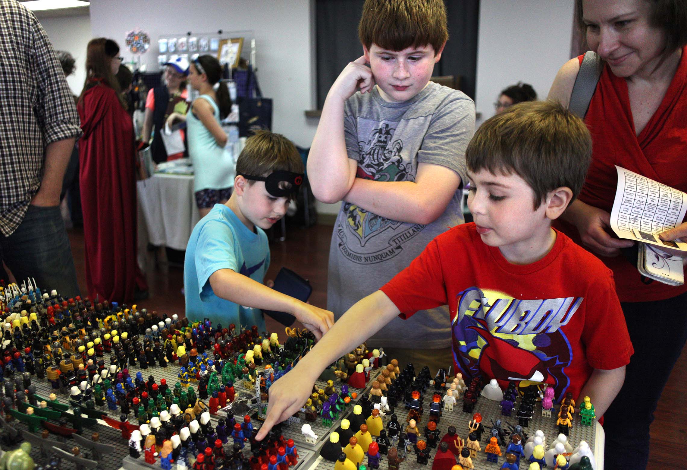  Harper Sexton, Logan Trudeau, and Colin Trudeau, from left to right, check out lego figures Saturday during the 8th Annual Kankakee Fantasy Con at the Kankakee Public Library. Logan and Colin's' father said they have a whole spare room dedicated to 