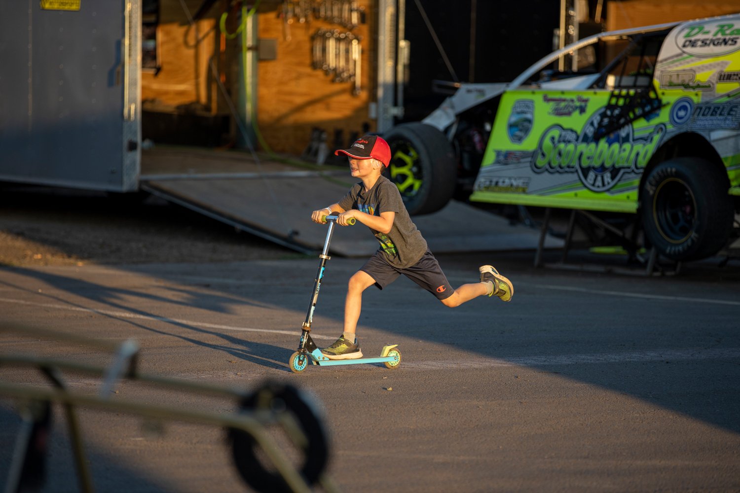 A racer's son flies by on a scooter in the pit Saturday at Willamette Speedway in Lebanon, Ore. The pit is full of racers, with kids in tow, working on their cars and karts prepping for their qualifying races or making tweaks before their final race