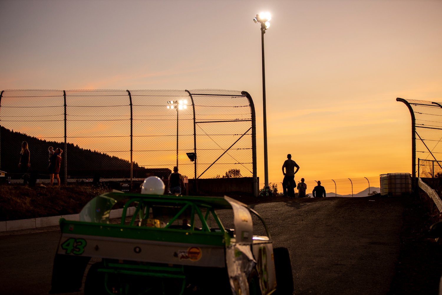  The sun sets over Willamette Speedway Saturday in Lebanon, Ore. as the crowd waits for the next race to start. The ⅓ mile dirt track hosts a wide variety of races, from tiny wingless sprint karts to street stock cars. 