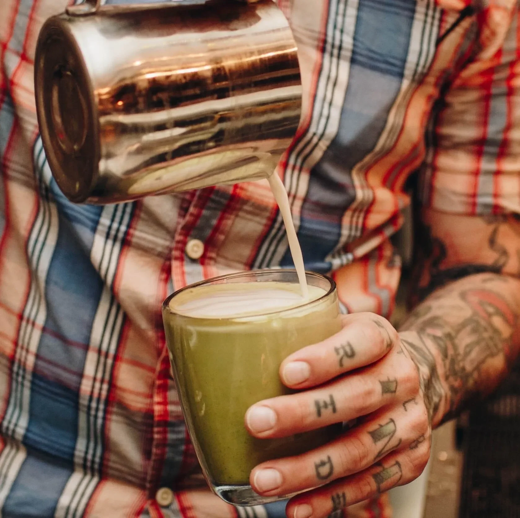A warm, spice-filled chai latte being poured to perfection, made with real brewed chai and creamy milk. This cozy Raleigh Raw favorite blends cinnamon, cardamom, and cloves for a smooth, aromatic drink crafted by hand.
