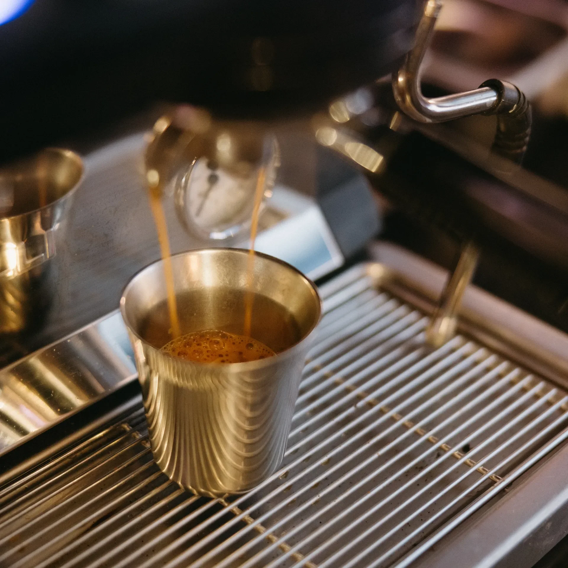 Fresh espresso pours into a stainless steel cup at Raleigh Raw, highlighting the rich crema and precision of our craft coffee process. A close-up look at smooth, bold espresso brewed to perfection for lattes, mochas, and specialty drinks.