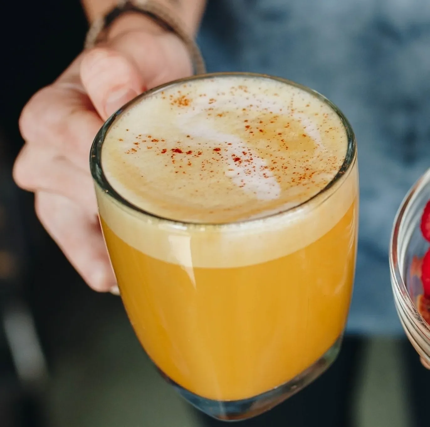 Warm and vibrant golden turmeric latte topped with a light foam and dusting of spices. A nourishing blend of turmeric, ginger, and cozy aromatics, this anti-inflammatory drink offers a soothing, immune-supporting boost at Raleigh Raw.
