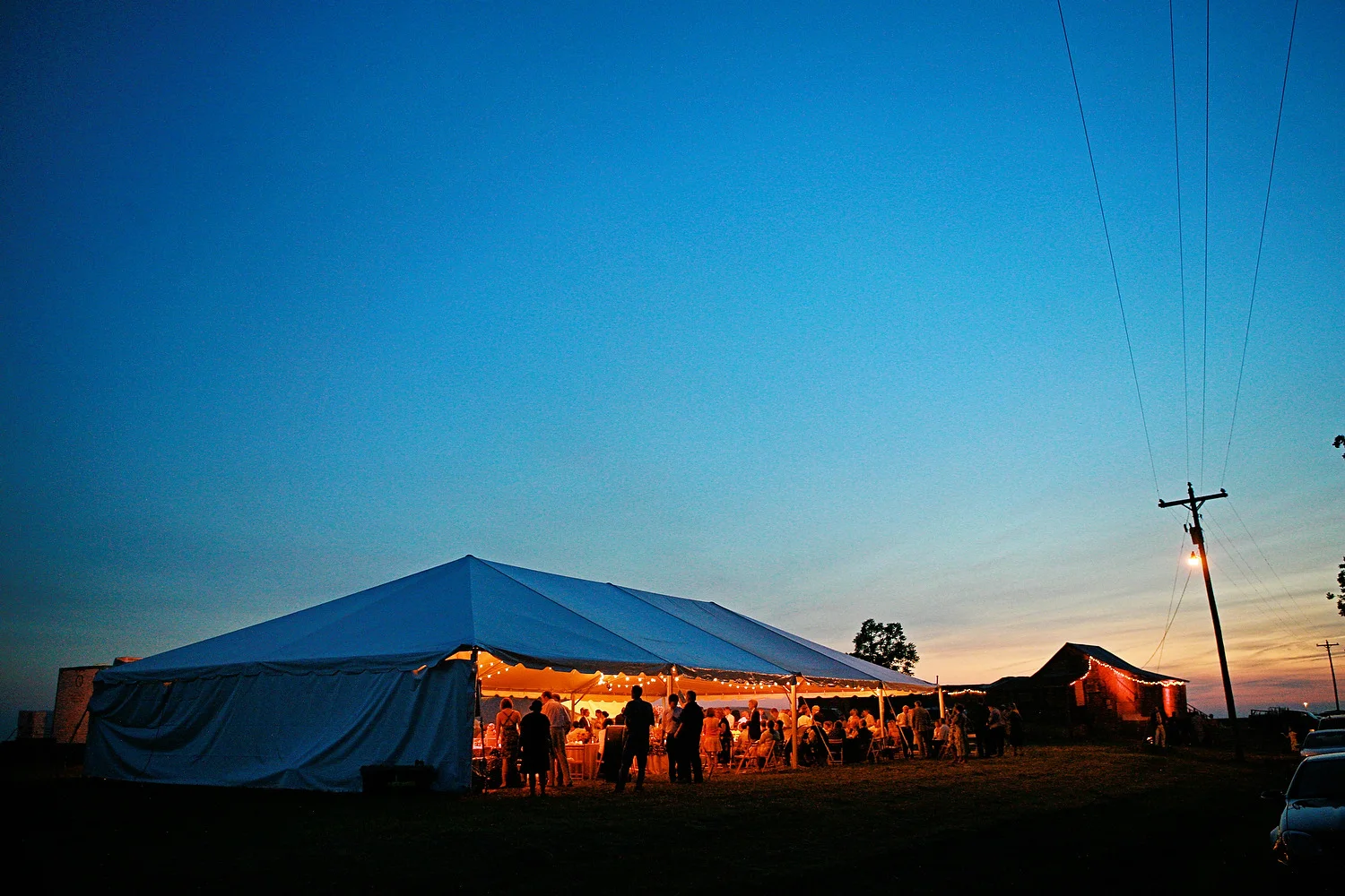 The reception marquee stands in a field next to Po' Monkey's juke joint (background) for John & Kate's wedding.