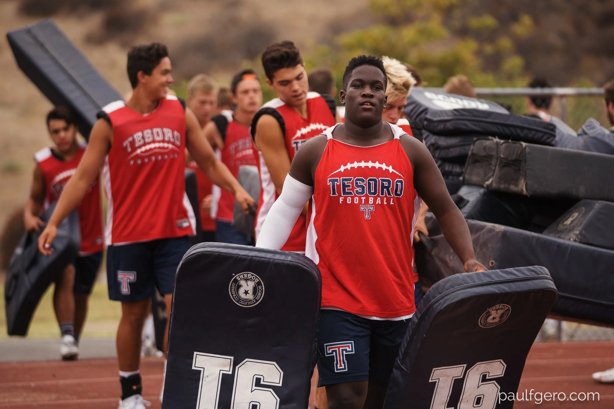 Tesoro players set up the field on Day One of Fall Camp at the school on Monday. 144 mm, 250 ISO, 1/50 0th at f2.8.
