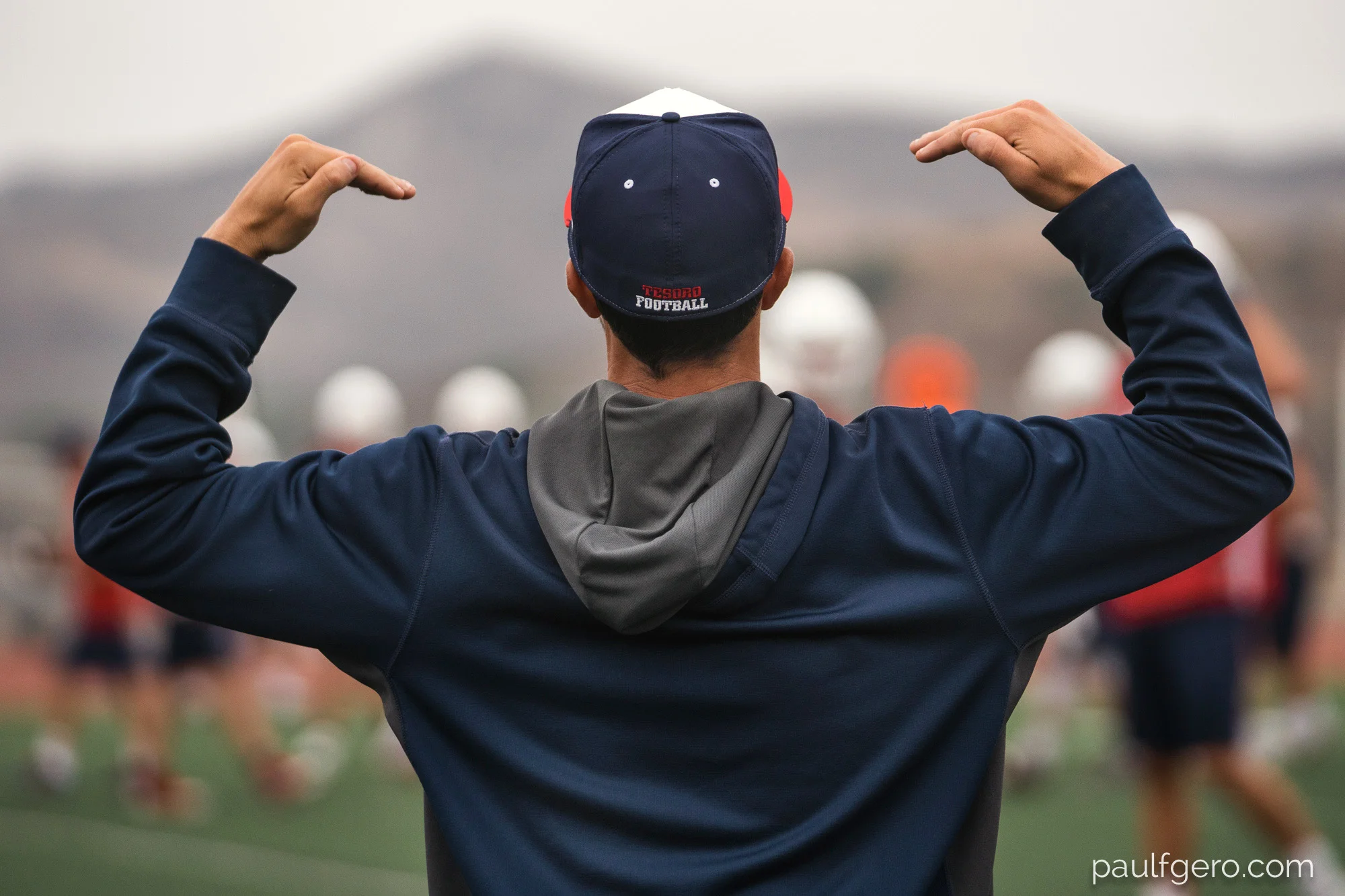 Tesoro Offensive Coordinator Preston King looks a bit like an orchestra conductor as he sends in signals from the side during Day One of Fall Camp at the school on Monday. 143mm, 400 ISO, 1/100 0th at f2.8.