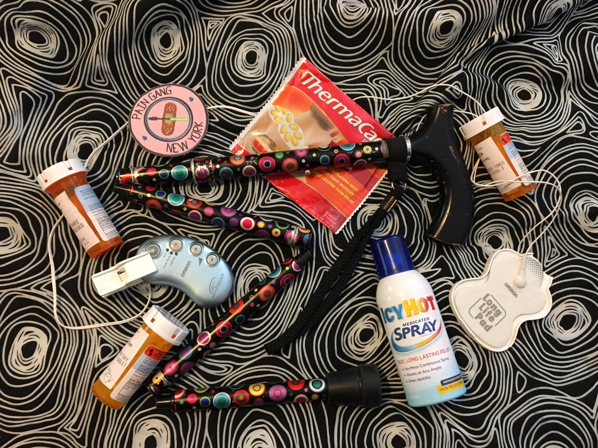 A cane, meds, IcyHot spray, therma patches, TENS machine, and a New York Pain Gang patch - all you need for successful gig survival.