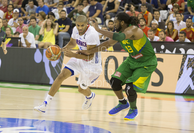 France's Nicolas Batum drives the lane on Brazil's Nene Hilario in Granada, Spain. 