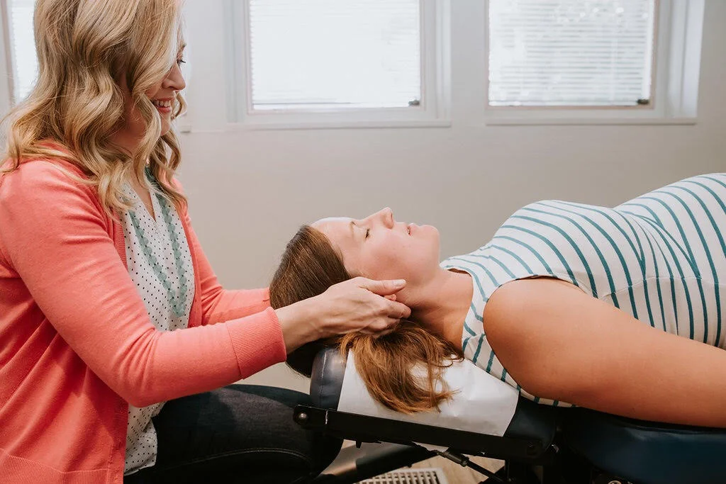 image description: a pregnant woman lies on her back while dr. jessica de nooij, her chiropractor, gently adjusts her.