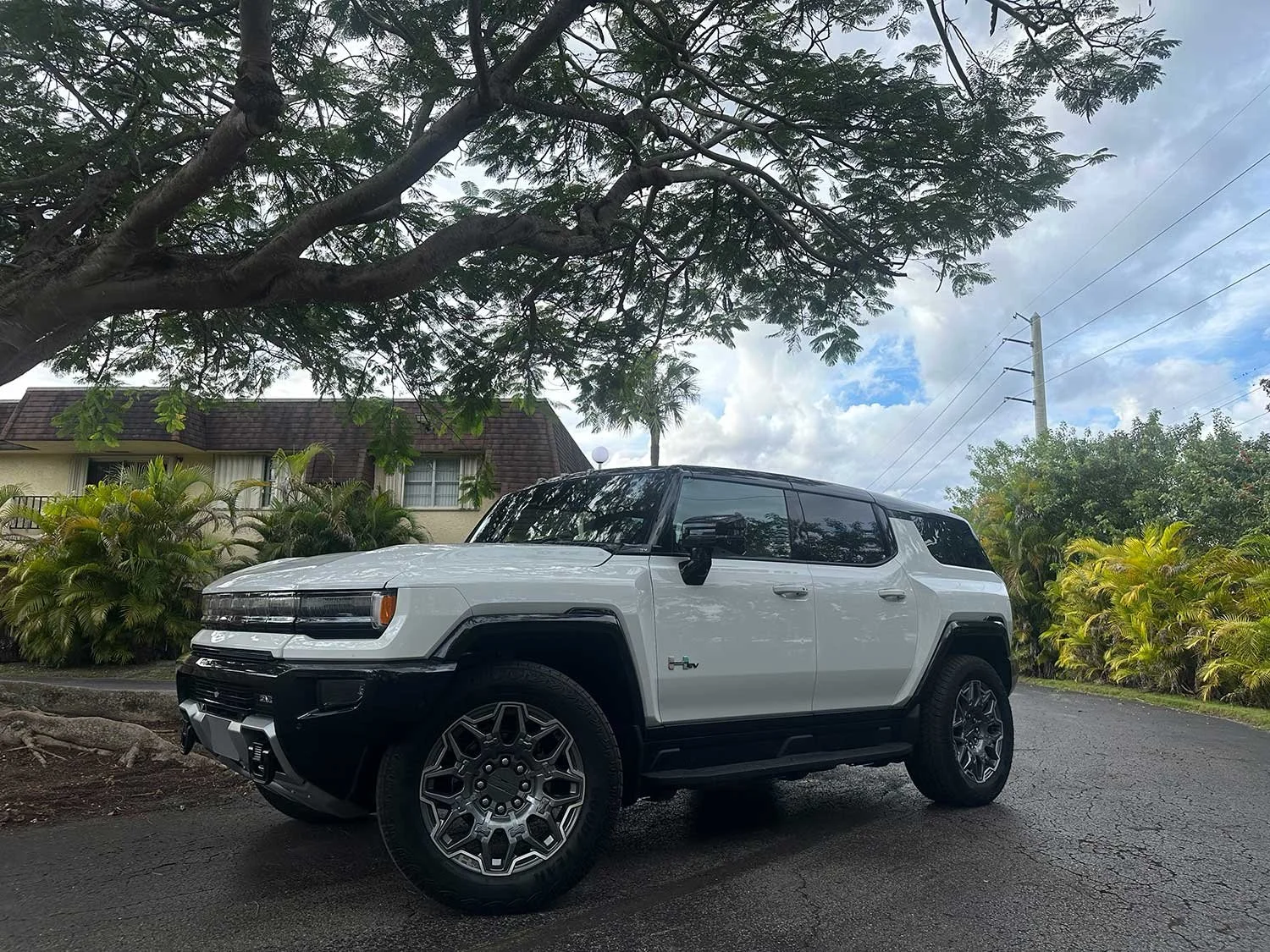 Las dimensiones y vista lateral del Hummer EV 2026 con casas de fondo