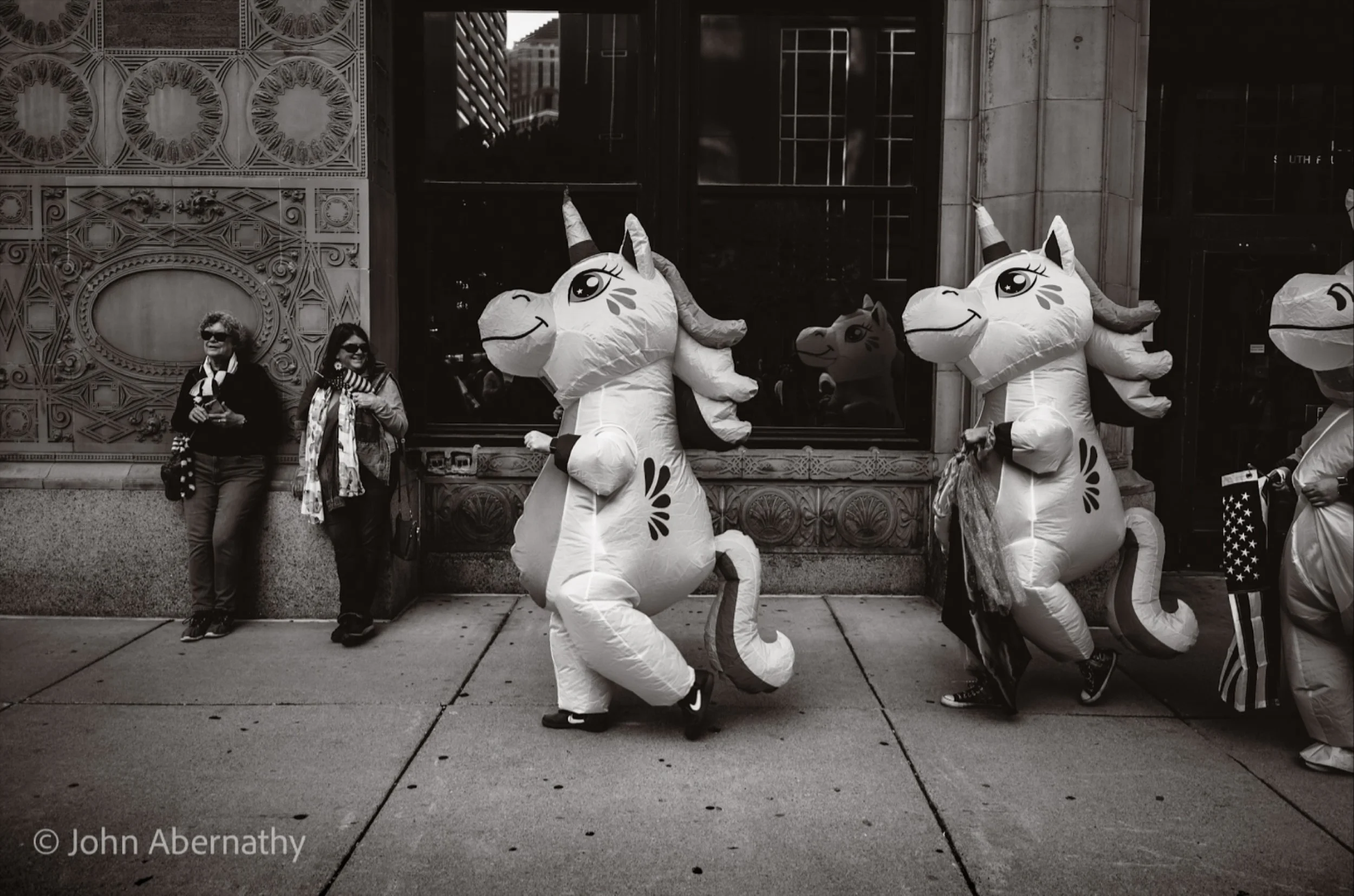 Two radical left unicorns trotted through downtown Minneapolis, hooves clacking on the sparkling pavement, shouting “No Kings!” into the mist while the violent frog-suit guy from Seattle livestreamed from a parallel protest dimension. The