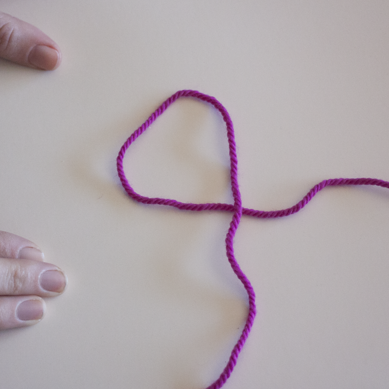 Start by laying the yarn in a number "4" formation.