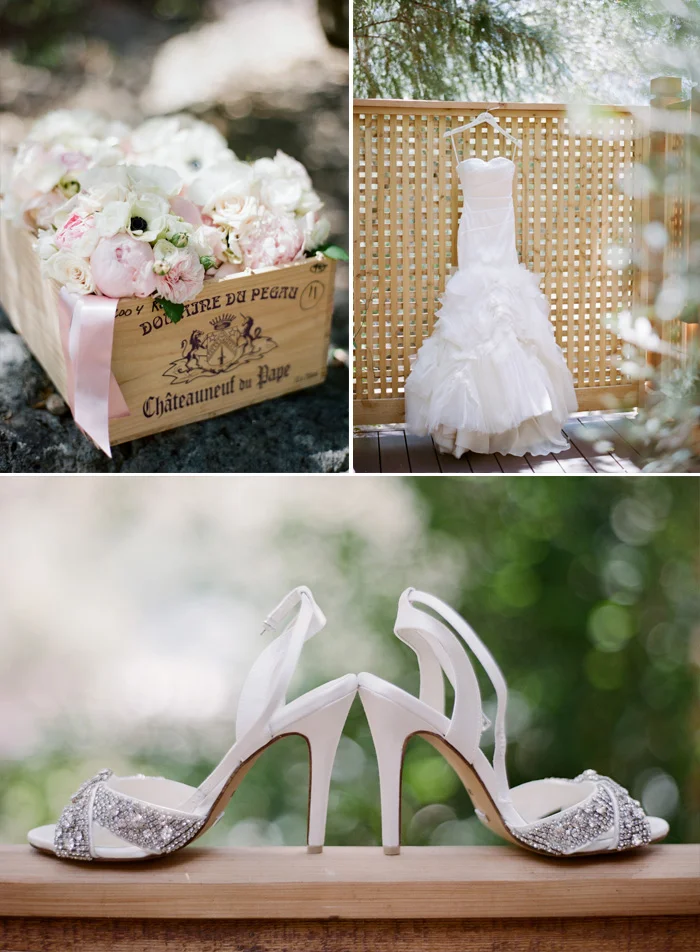 Lauren's gorgeous wedding gown hangs on a fence before the ceremony, also pictured are her heels and a box of on-theme blush florals; photo by Sylvie Gil