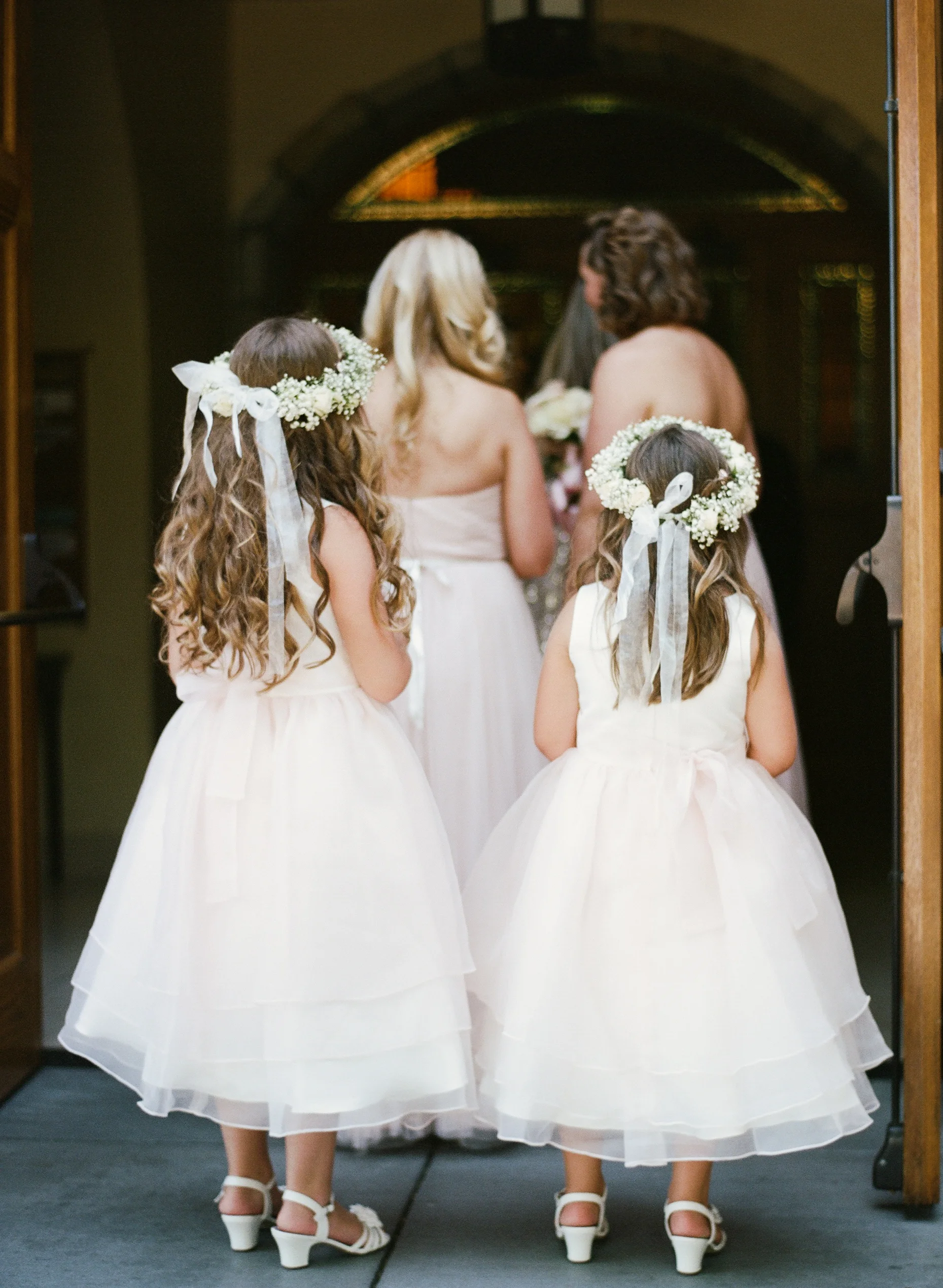 Flower crown-wearing flower girls line up in the ceremony procession into the church; photo by Sylvie Gil