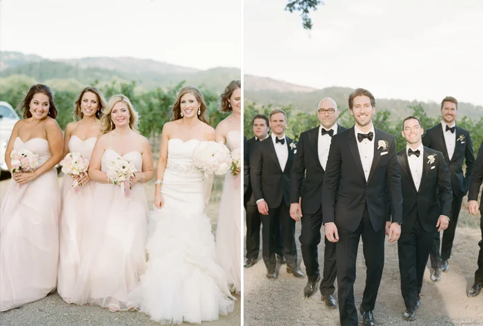 The bridesmaids in blush and groomsmen in dapper black tuxedos walk toward the camera during a bridal party shoot; photo by Sylvie Gil