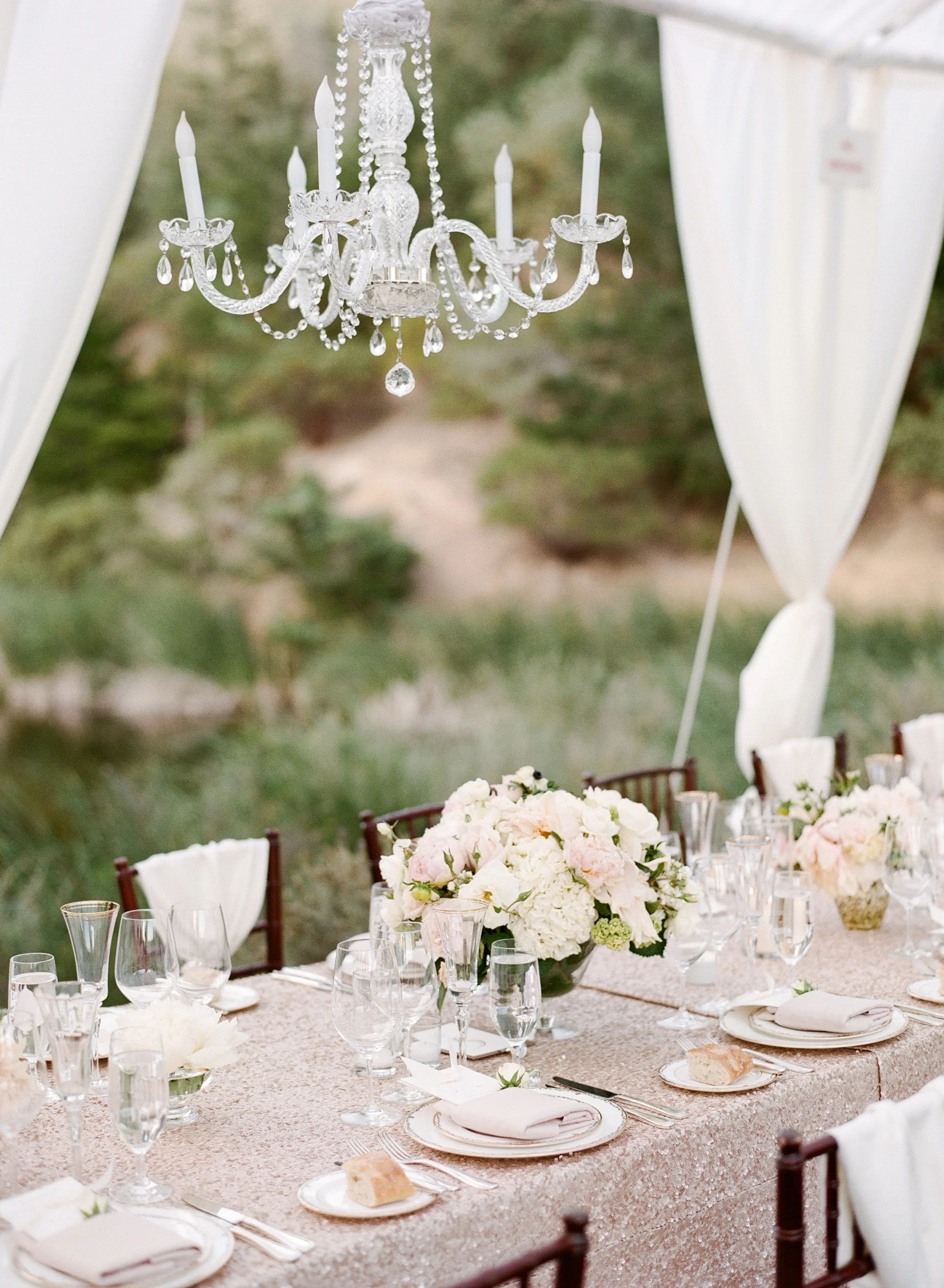The canopied outdoor reception boasted glittering tablecloths and elegant chandeliers, as well as matching blush centerpieces; photo by Sylvie Gil