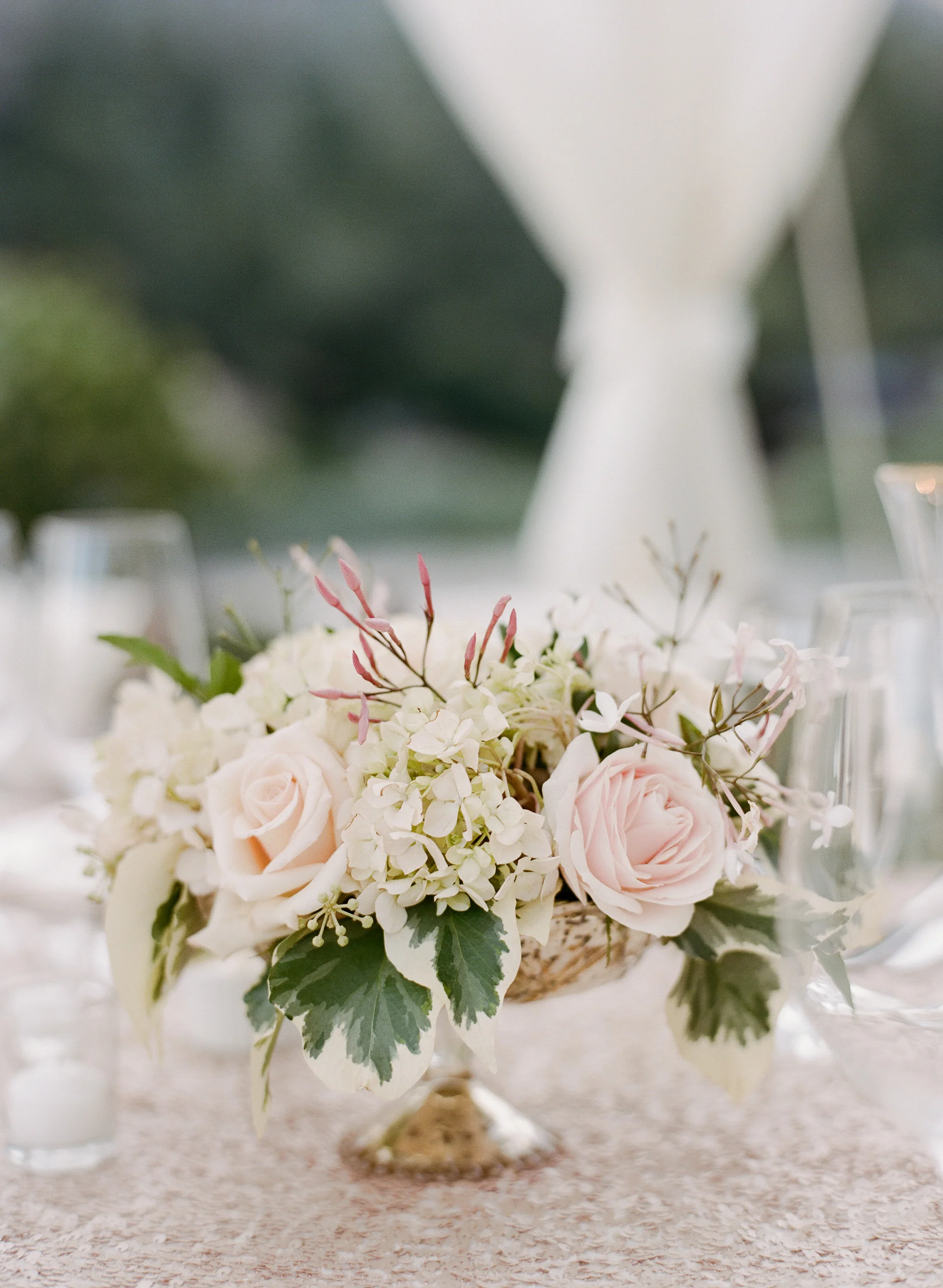 A subtle accent floral arrangement combines hydrangeas with blush roses; photo by Sylvie Gil