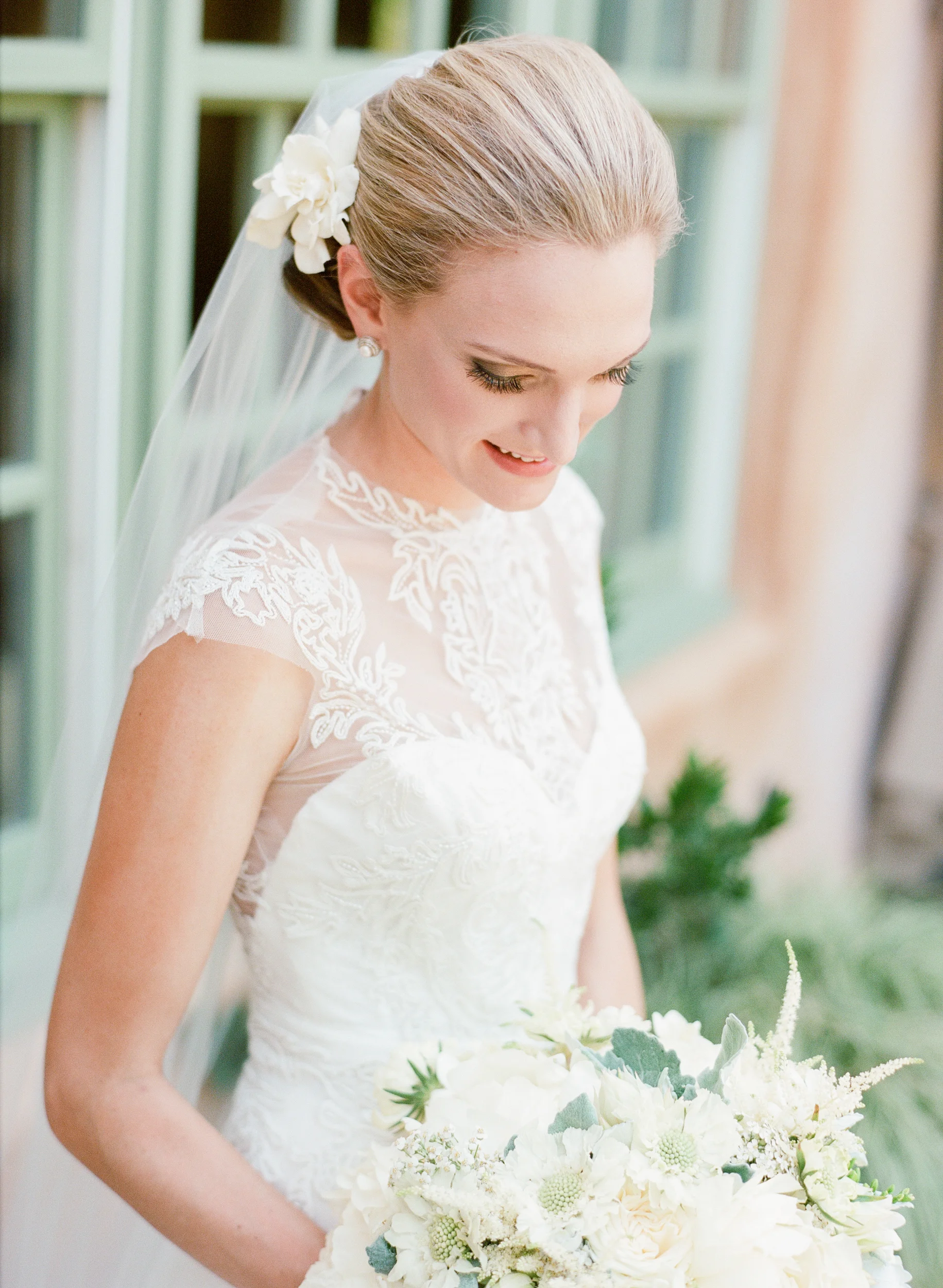 Bride in Monique Lhuillier gown holds bouquet; Sylvie Gil Photography