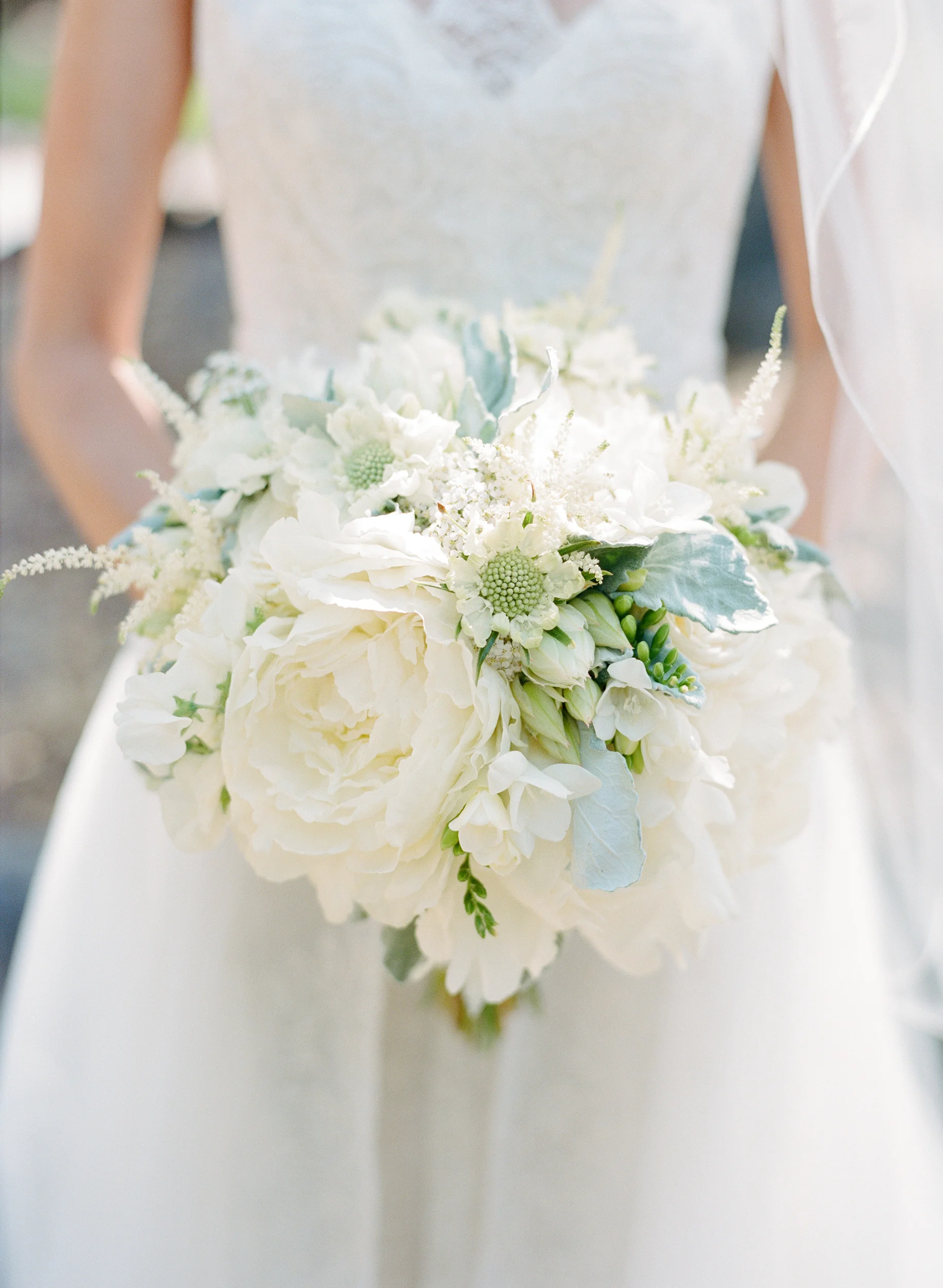 Bride holds white and green peony bouquet; Sylvie Gil Photography