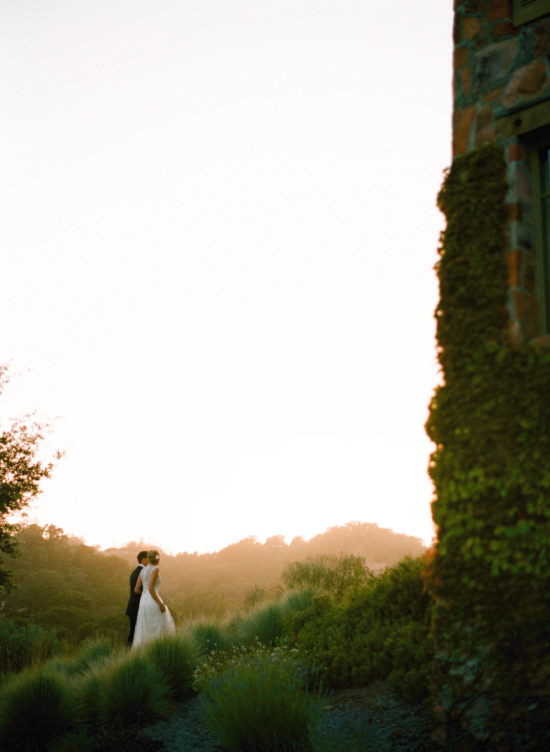 Bride and groom walk through ethereal sunset light in Calistoga Ranch; Sylvie Gil Photography