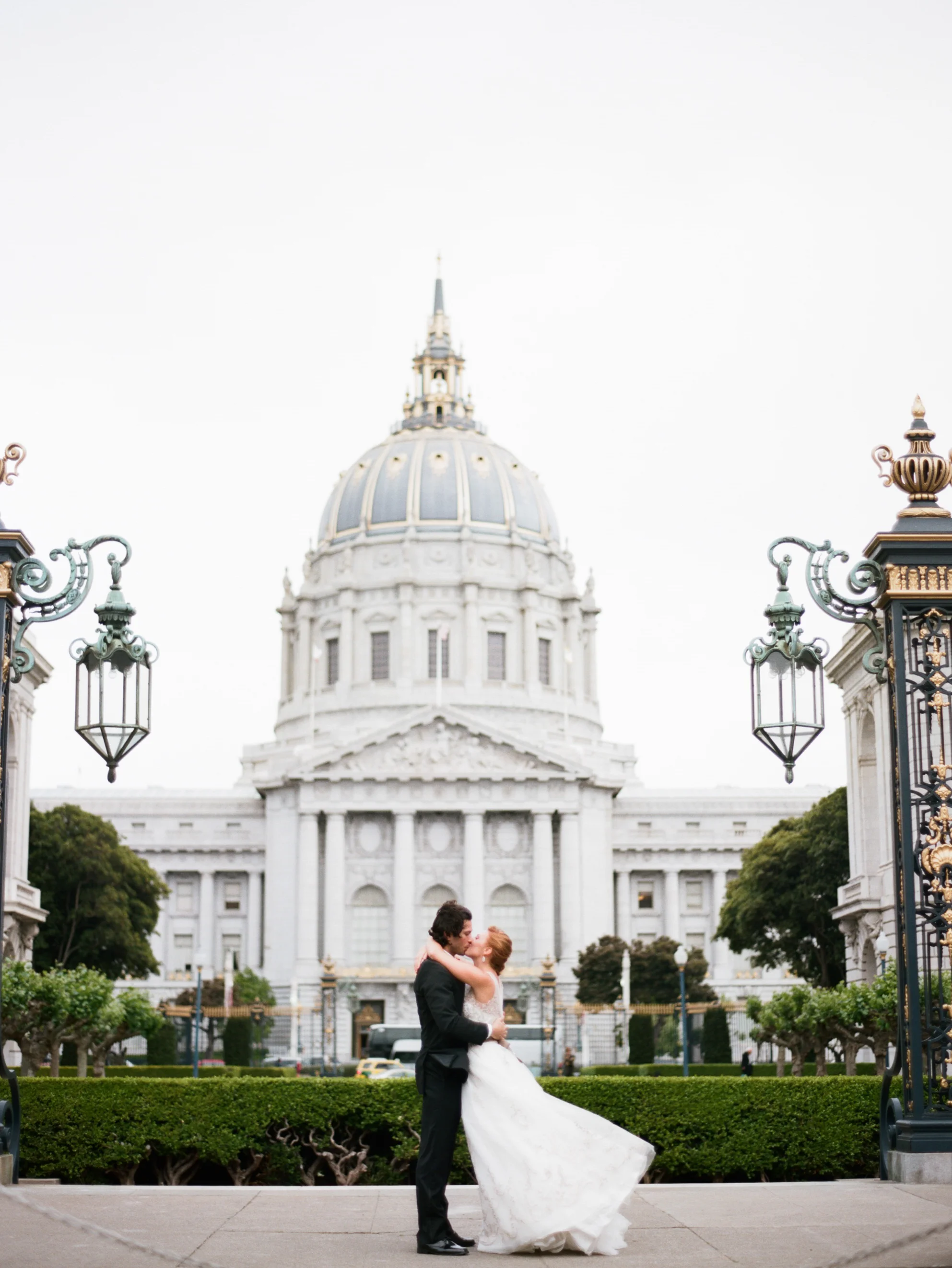 Bride and groom kiss outside San Francisco City Hall, just married; Sylvie Gil Photography