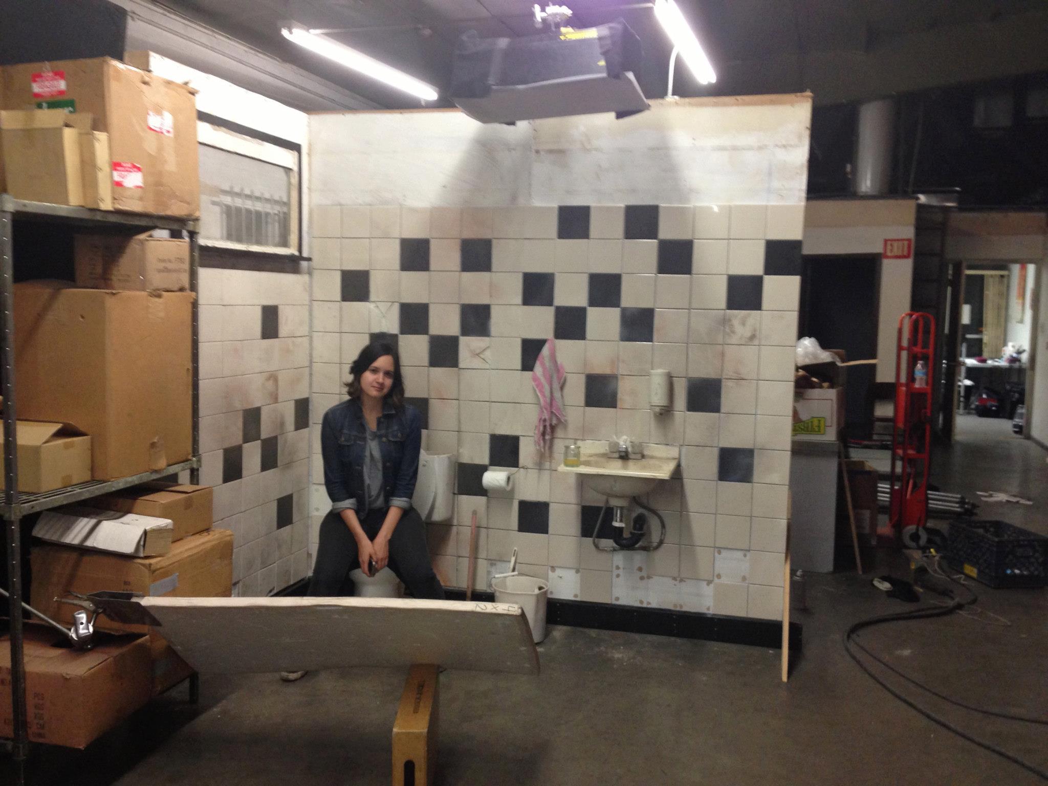 Producer Amanda Garque on the bathroom set.