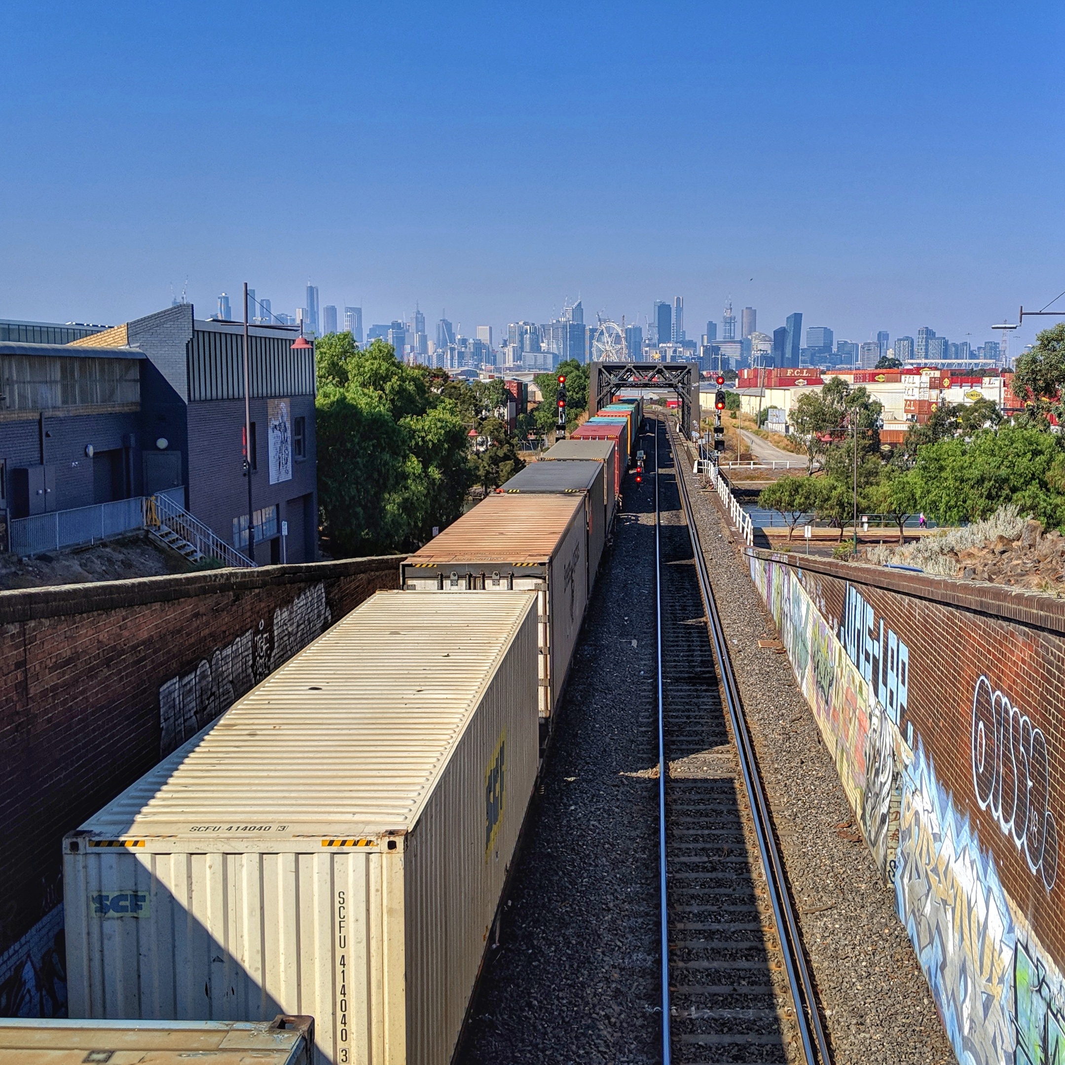 A freight train heading towards Melbourne city on the South Kensington–West Footscray railway line, next to Footscray station.