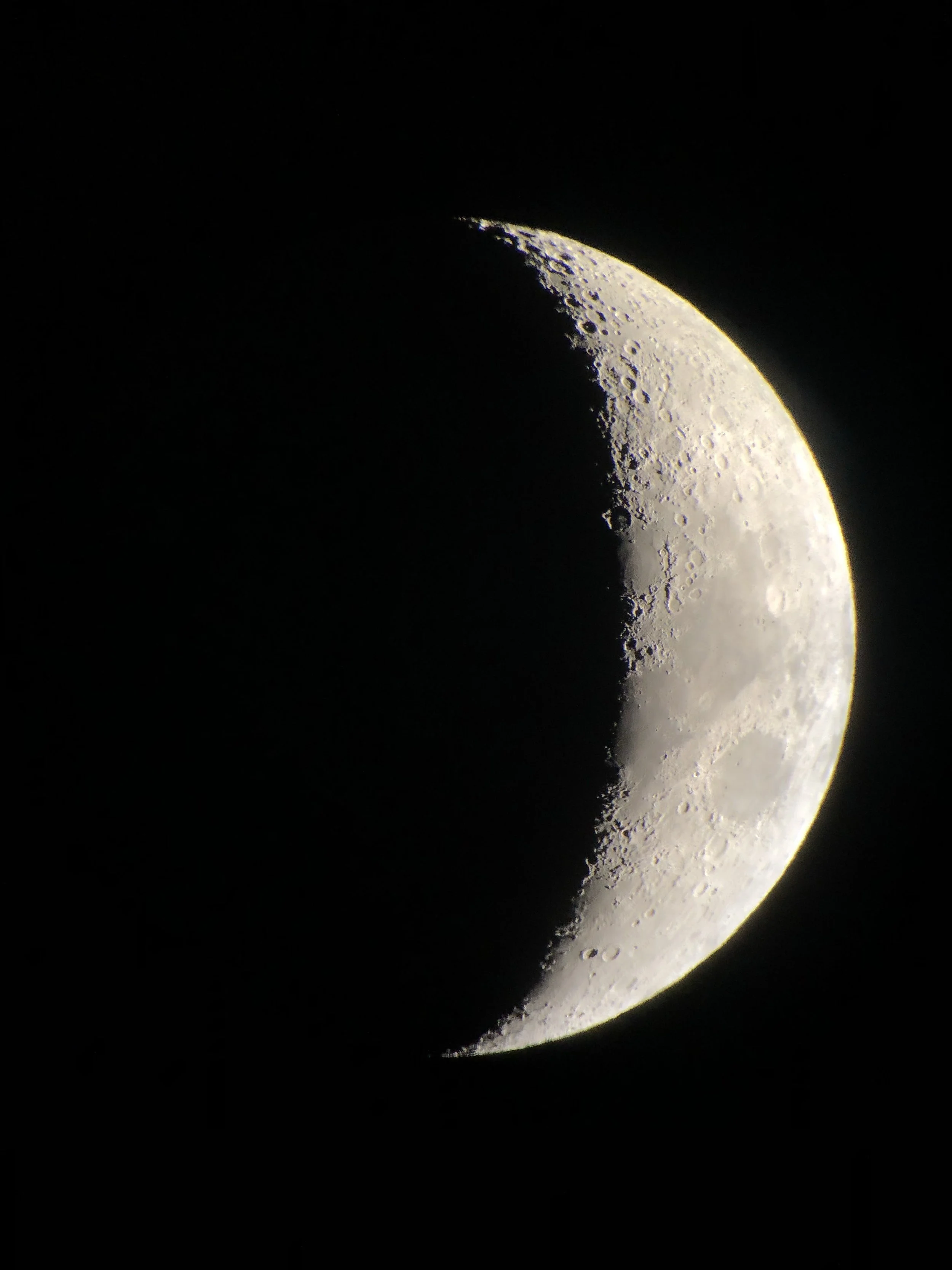 A photograph of the Moon taken through a telescope in Hawaii in 2018, showing details of its cratered surface.
