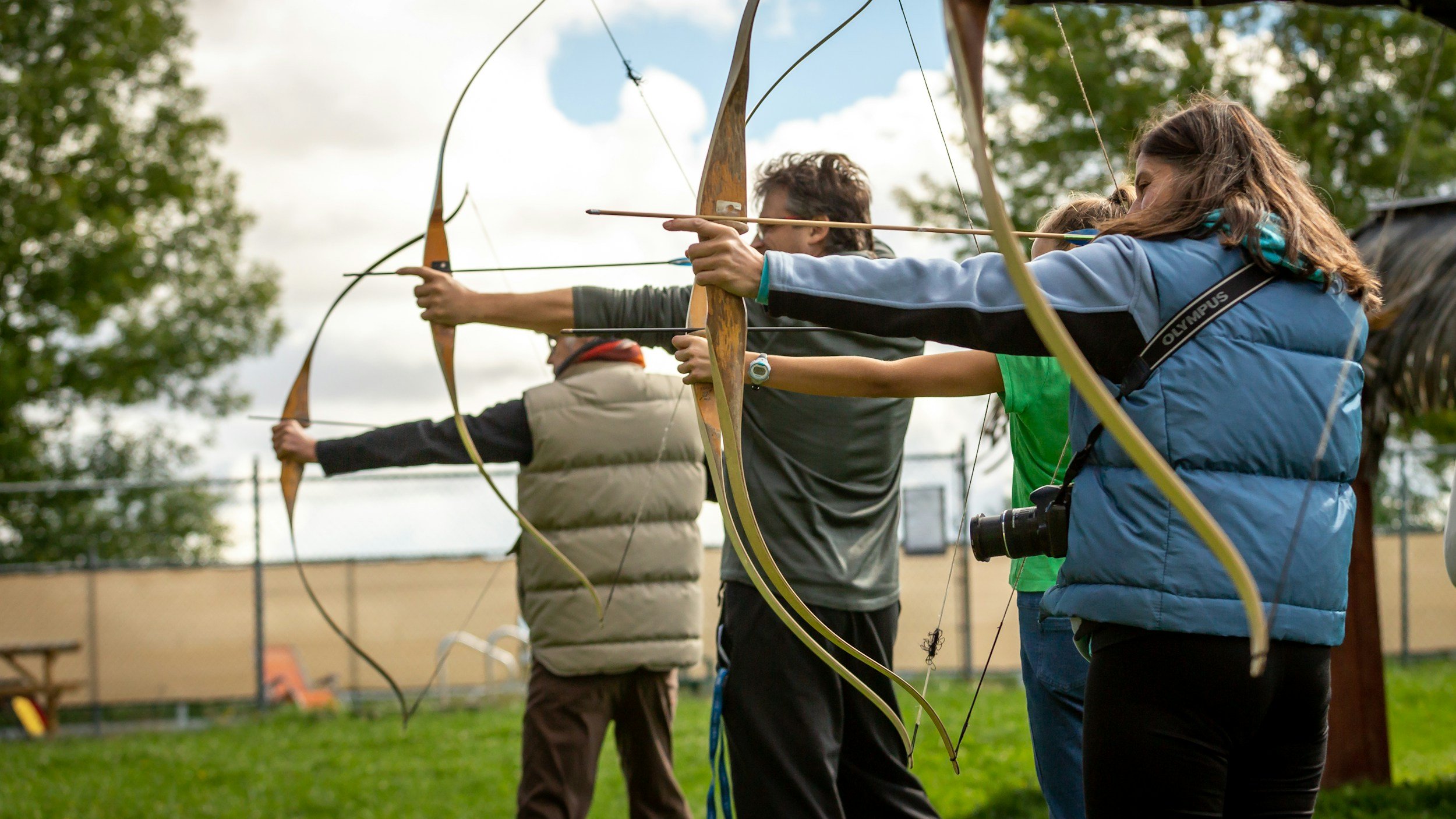 A group of archers on a practice range at full draw