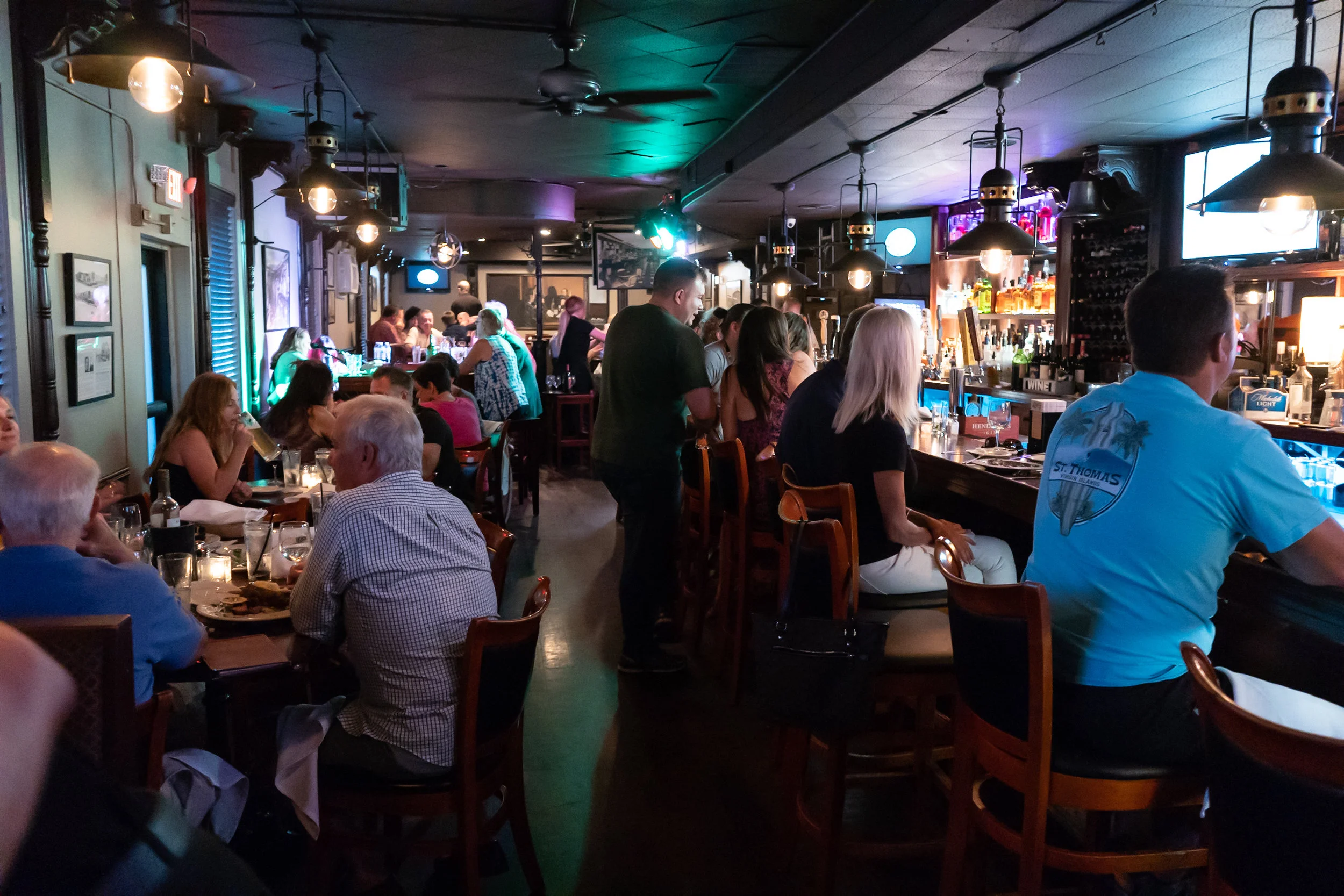 Guests seated in the warmly lit bar at Fenton Hotel Tavern & Grille