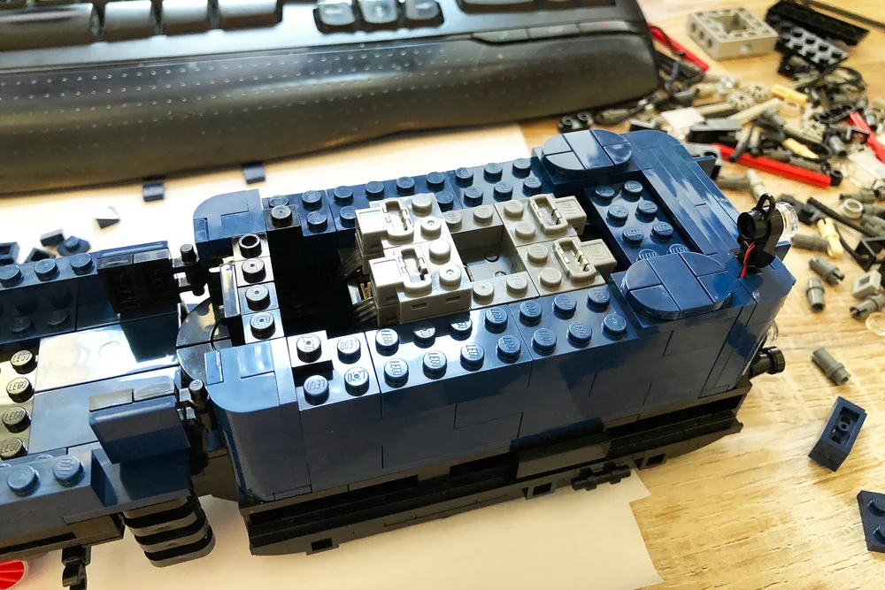  The Buwizz battery and receiver placed in the tender. Four plugs for lighting and on the back one for each engine. In the middle you can reach the on/off switch and the charging point. 