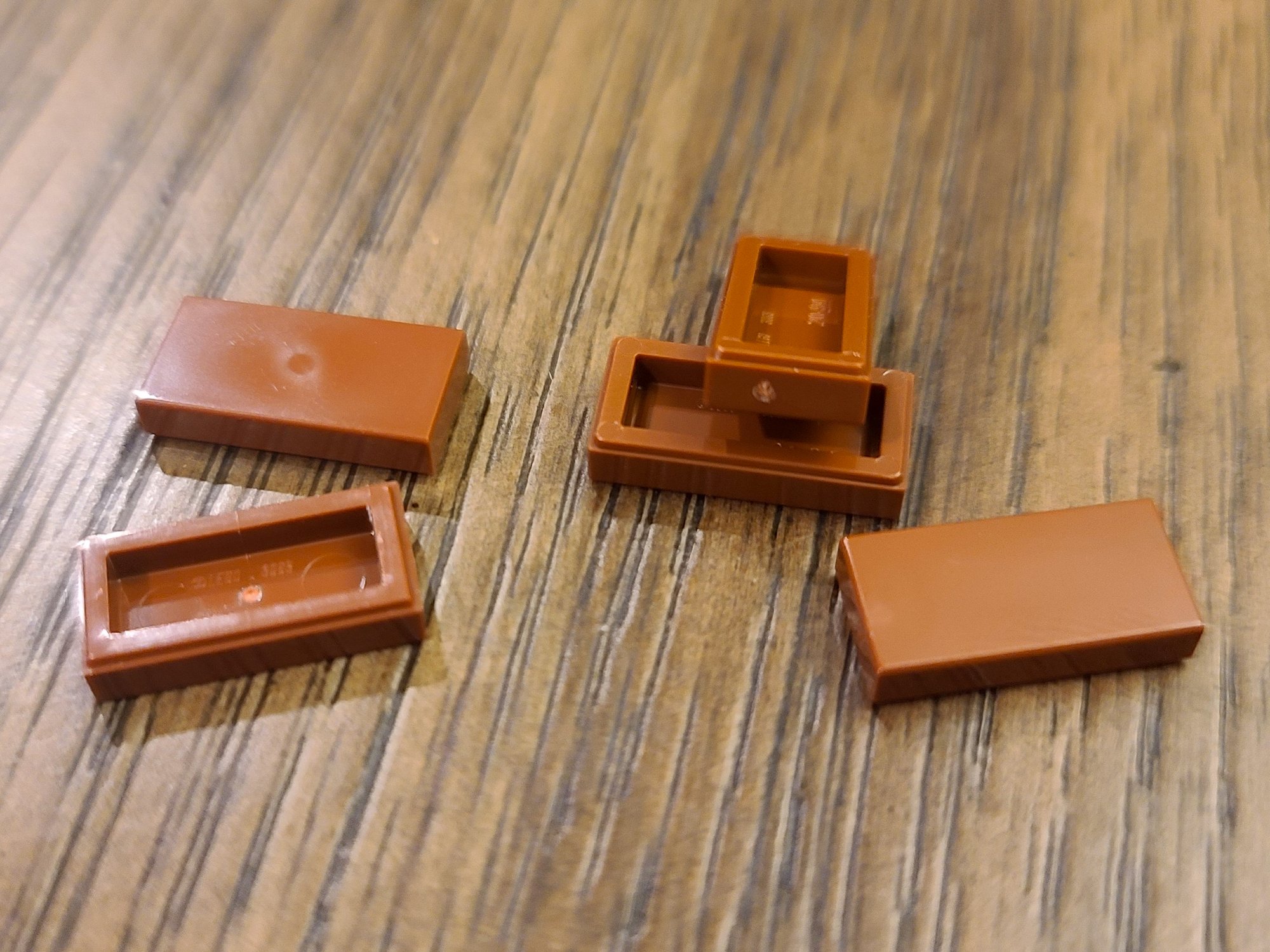 As someone who likes to orient the injection points on LEGO pieces away from view, I noticed there are two different kinds of molds for the 1x2 tiles.