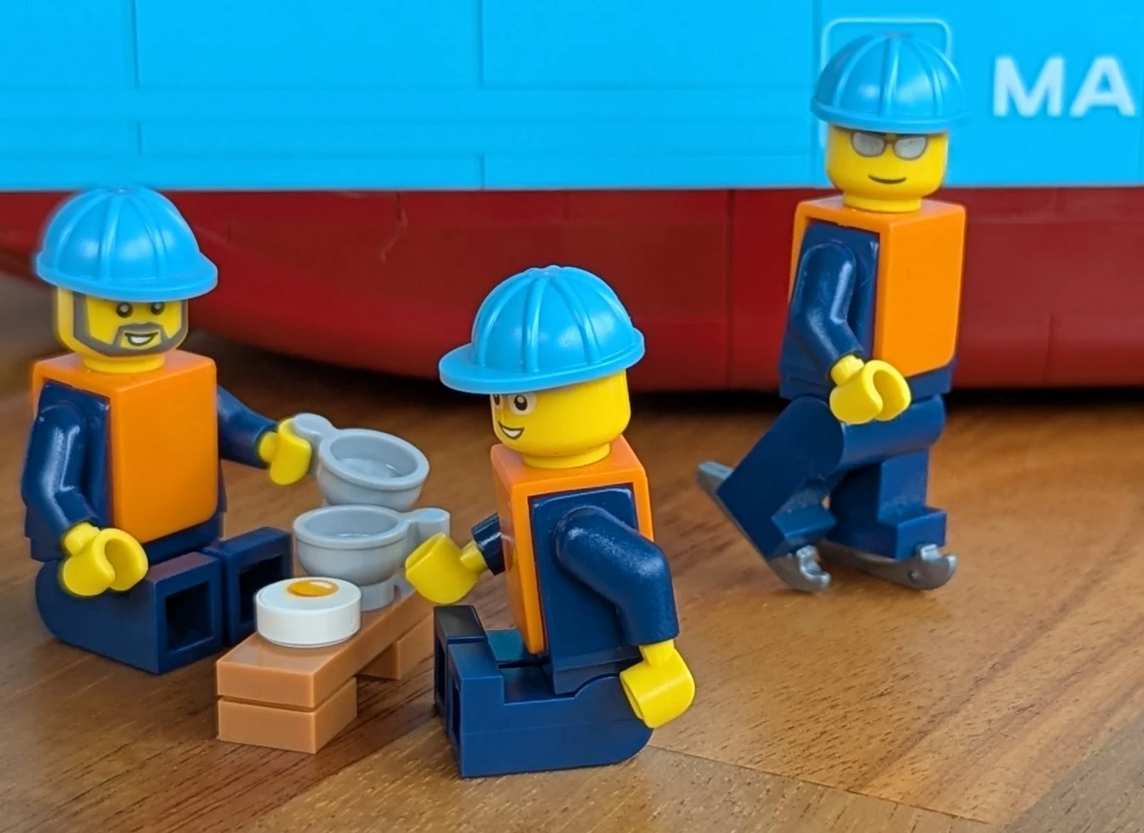 Two minifigures having a cuppa while a third is skating by.