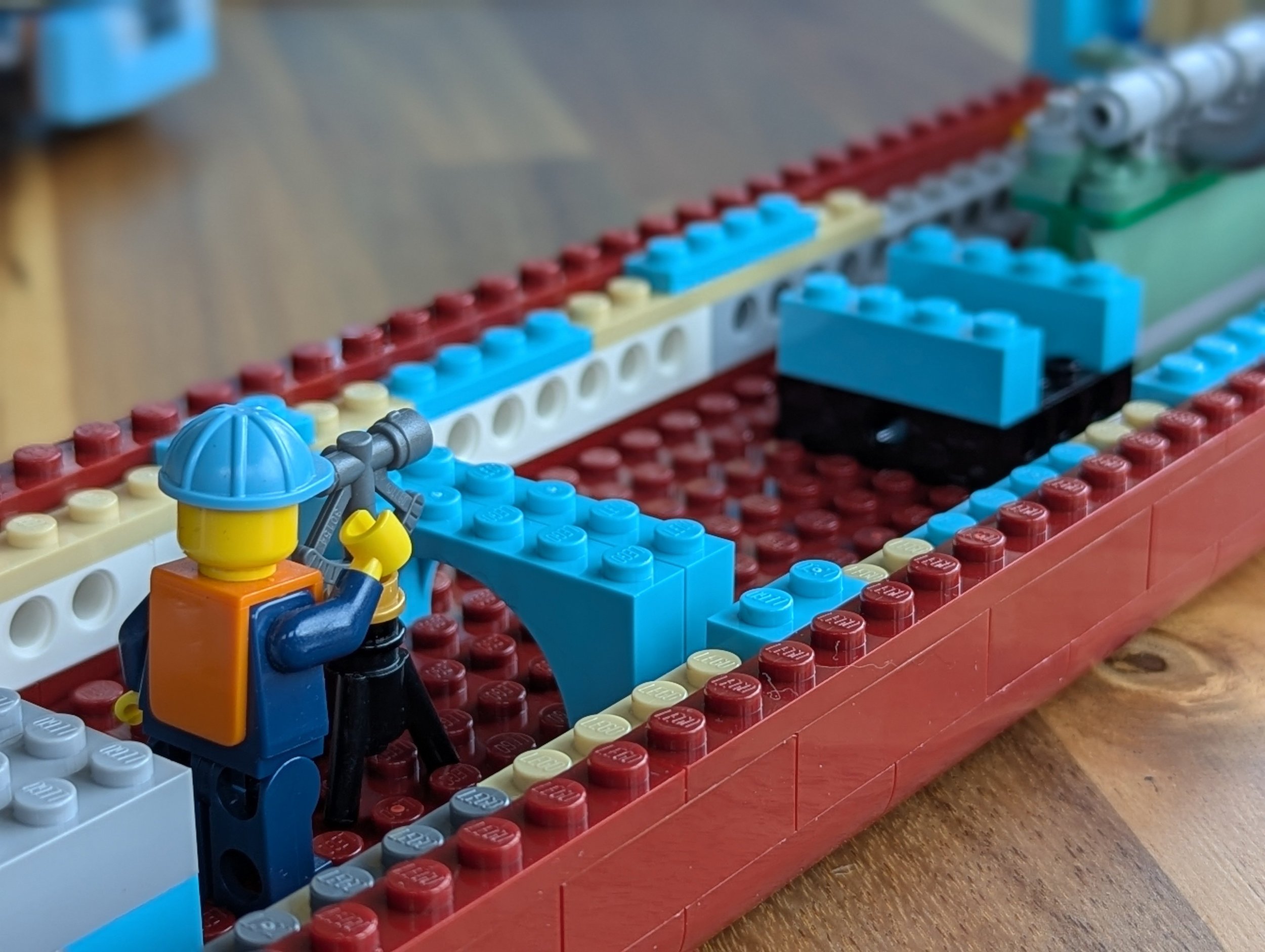 Minifigure construction worker checking the engine placement with an instrument