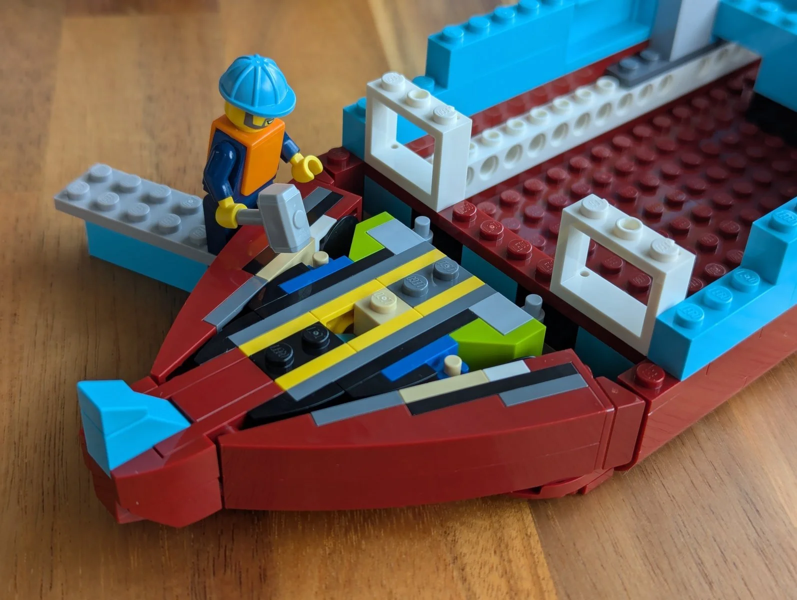 Construction worker minifig with hammer above the colorful inside of the bow.