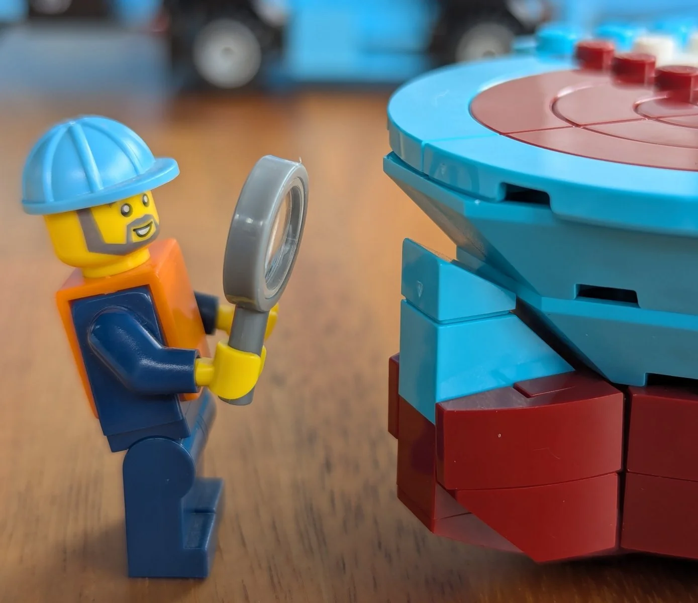 Minifigure with magnifying glass looking at a gap in the bow construction.