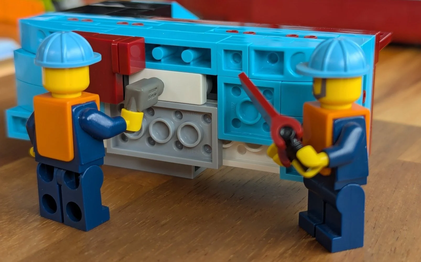 Minifigure construction workers placing the rudder.