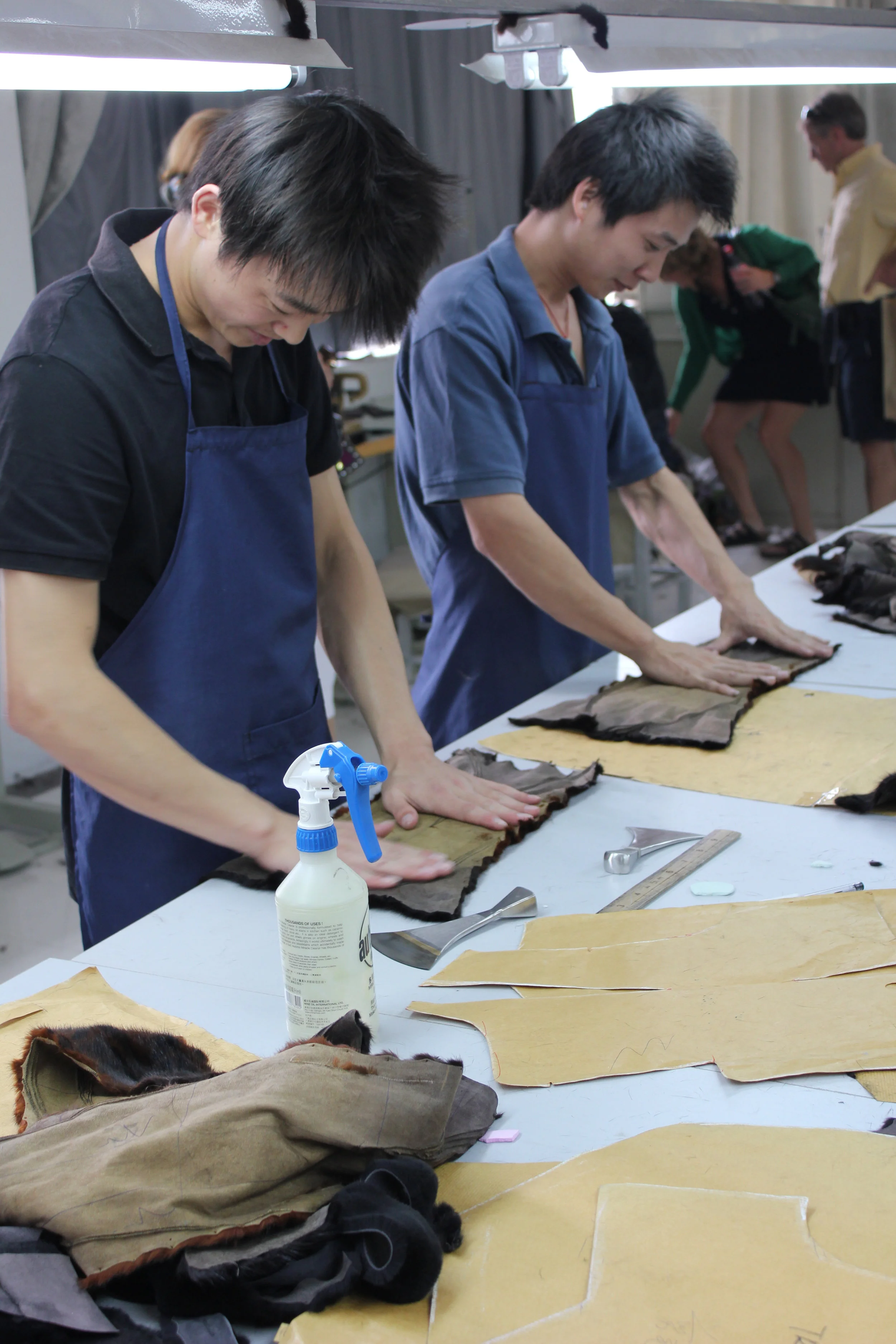 Up in the main manufacturing warehouse, workers match cut pieces of pelts to larger garment patterns.