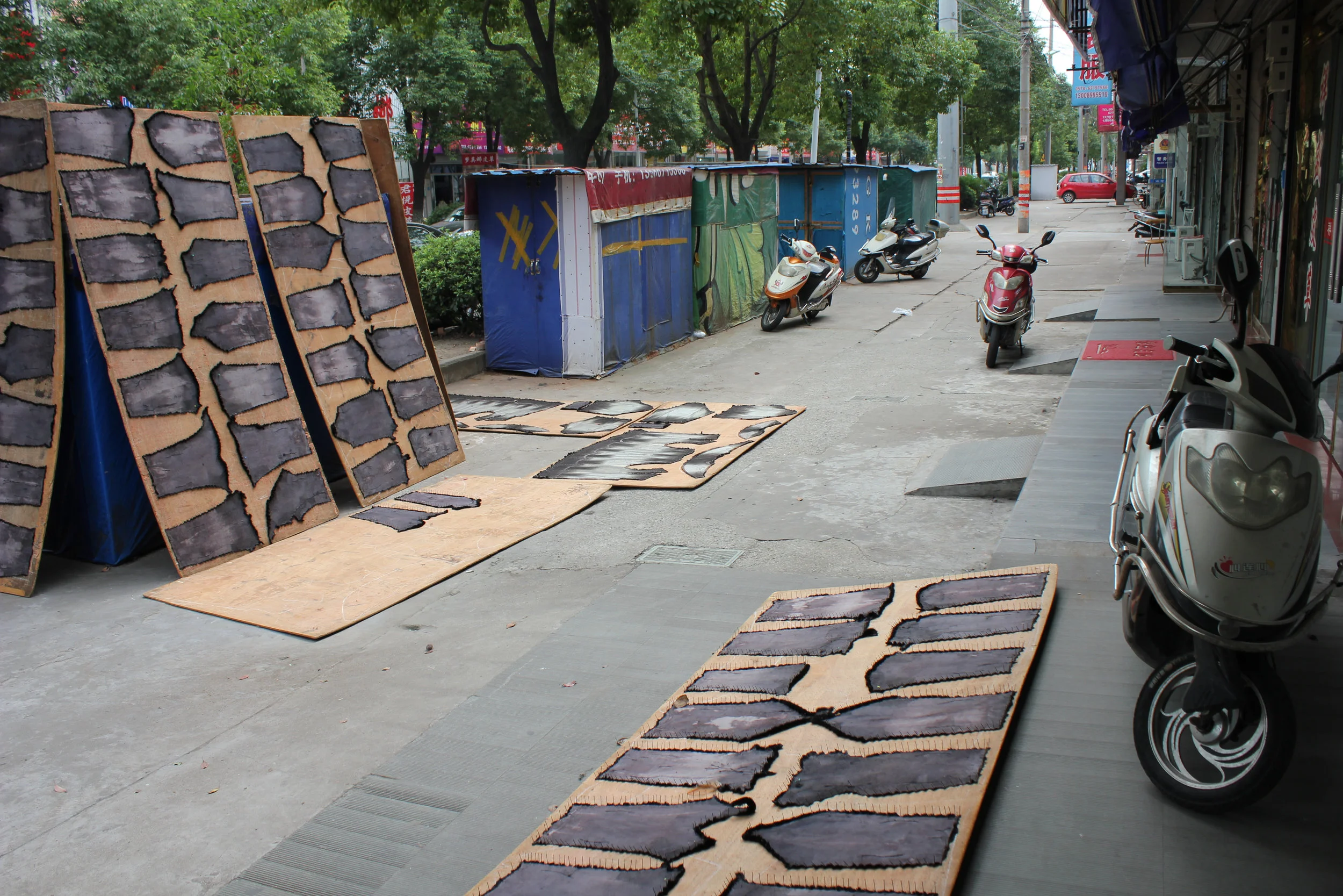 Any available surface is a good enough surface for the neighborhood's workers to lay out patterned goods in process.
